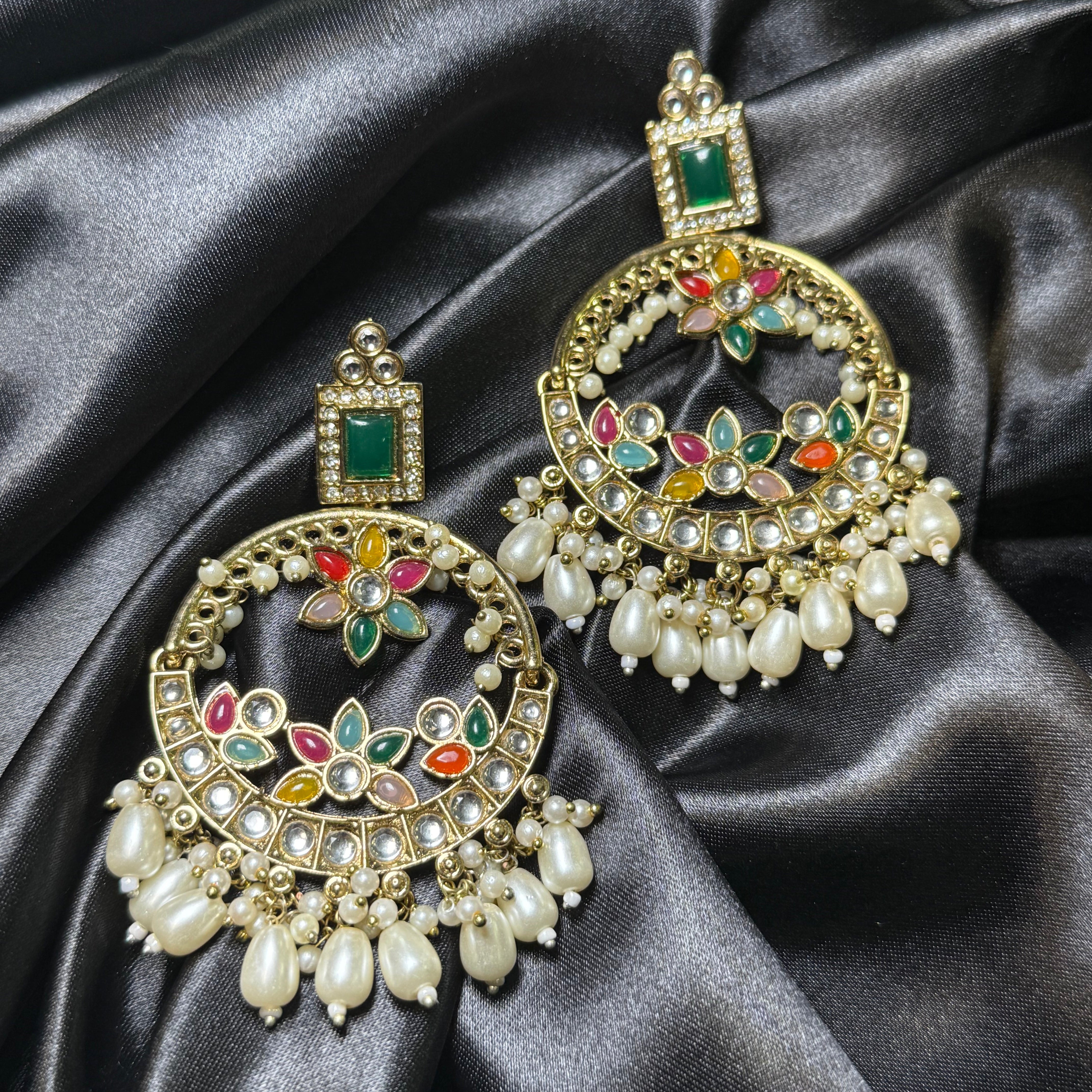 Decorative earrings with gemstones on a dark satin fabric