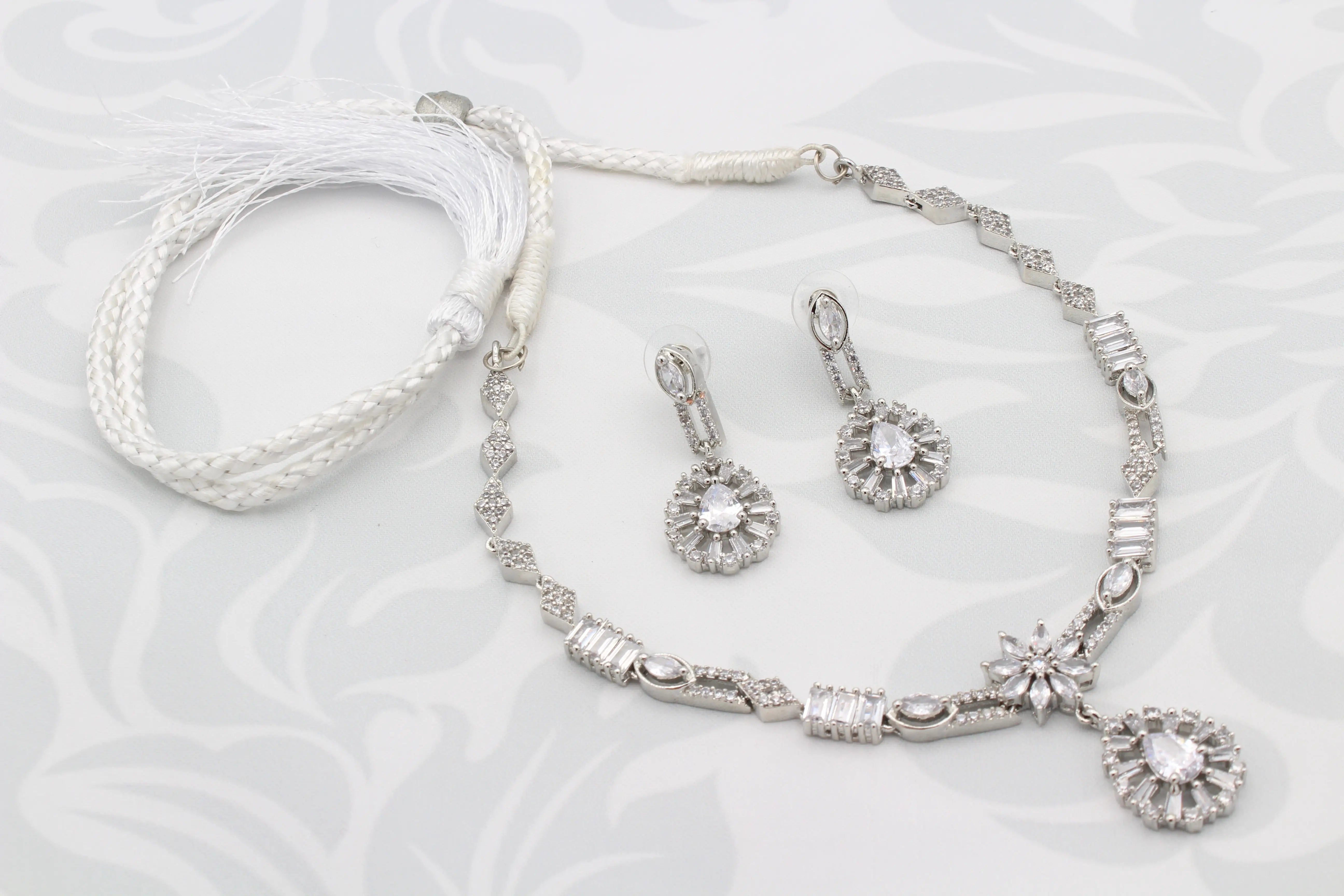 Full view of Frosted White Necklace Set with adjustable tassel tie and matching earrings on white background