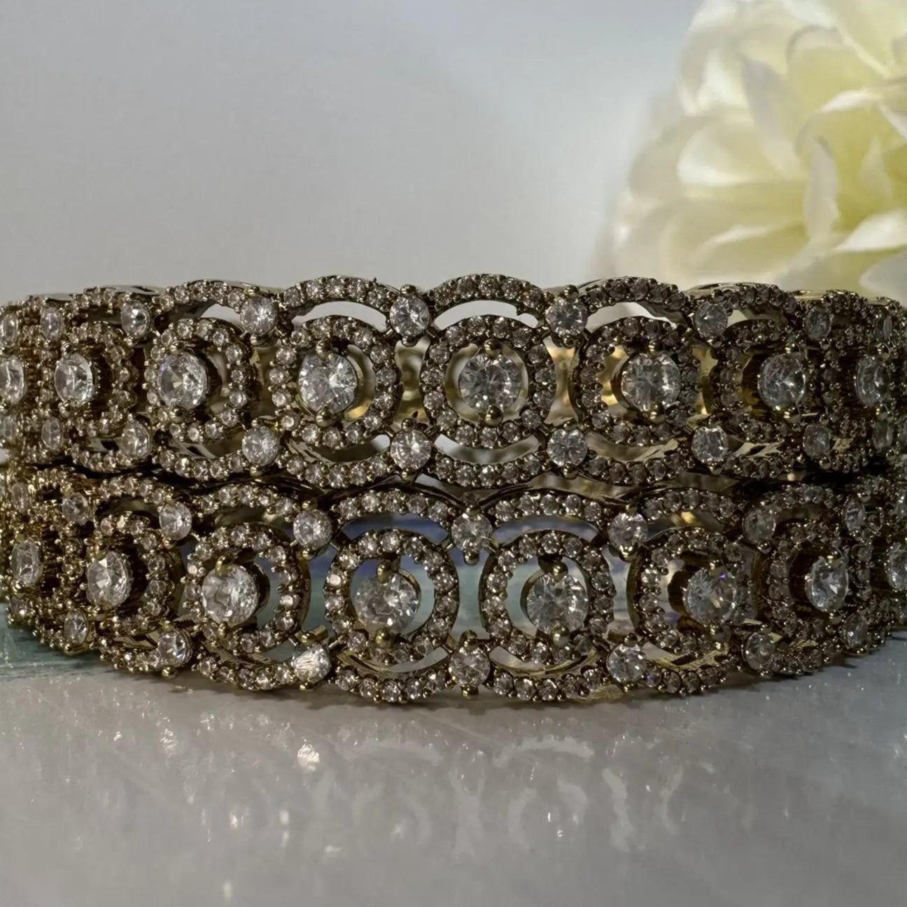 closer view of gold-plated American diamonds bangles with antique polish for lasting shine and anti tarnish capabilities on a white background