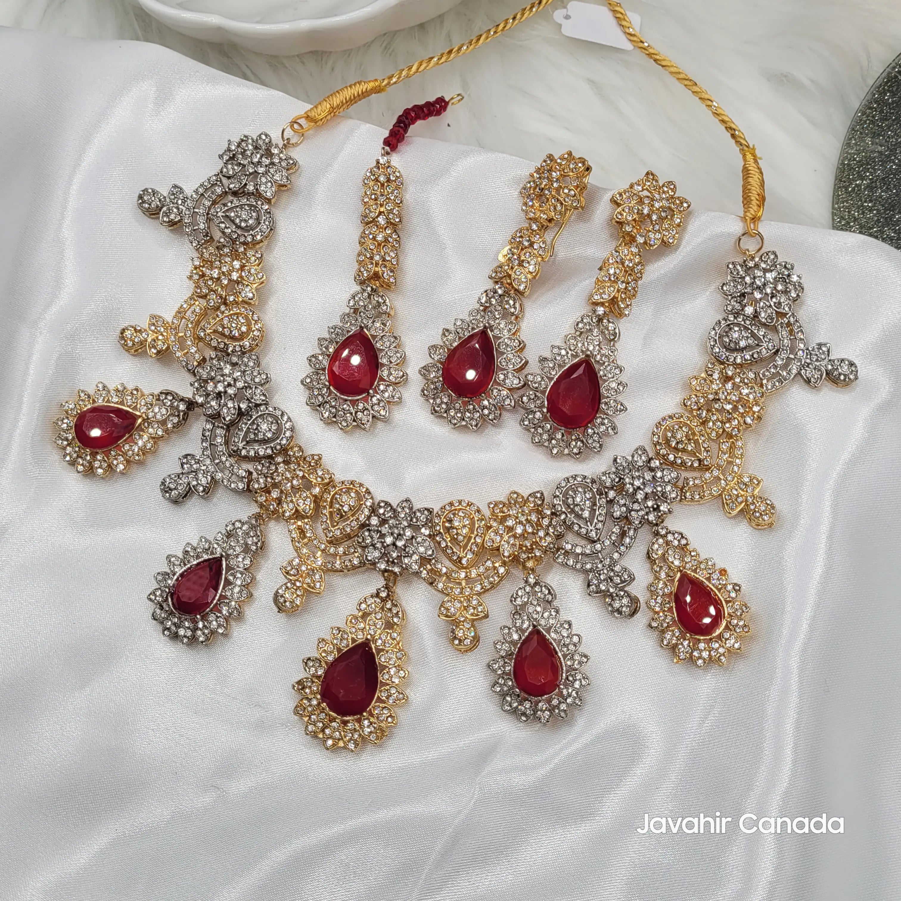 Full display of the JV155 set including necklace, earrings and teeka laid on white satin, highlighting intricate dual-tone details.