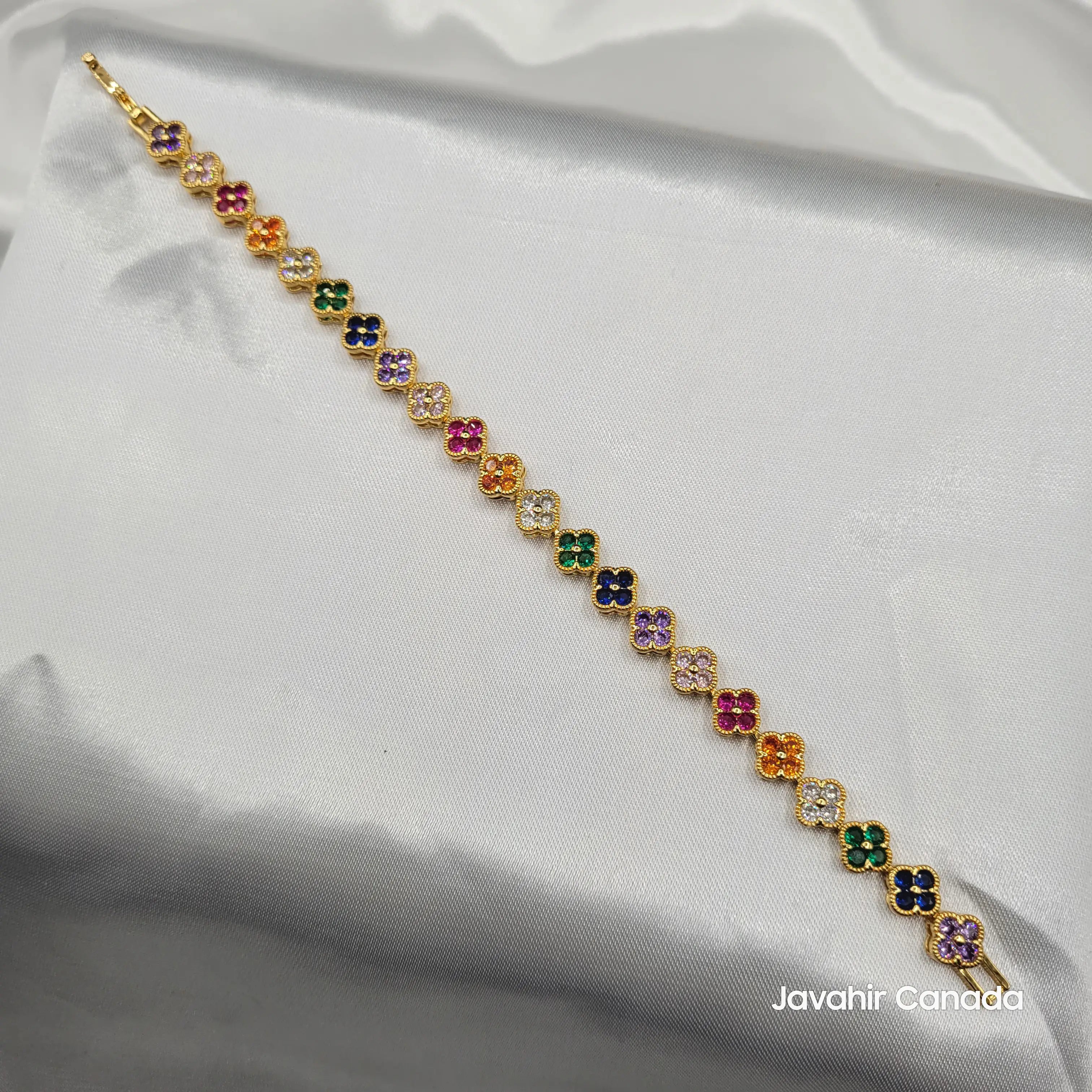 JV4013 gold-tone multicolor floral bracelet with rainbow cubic zirconia flowers laid on satin background