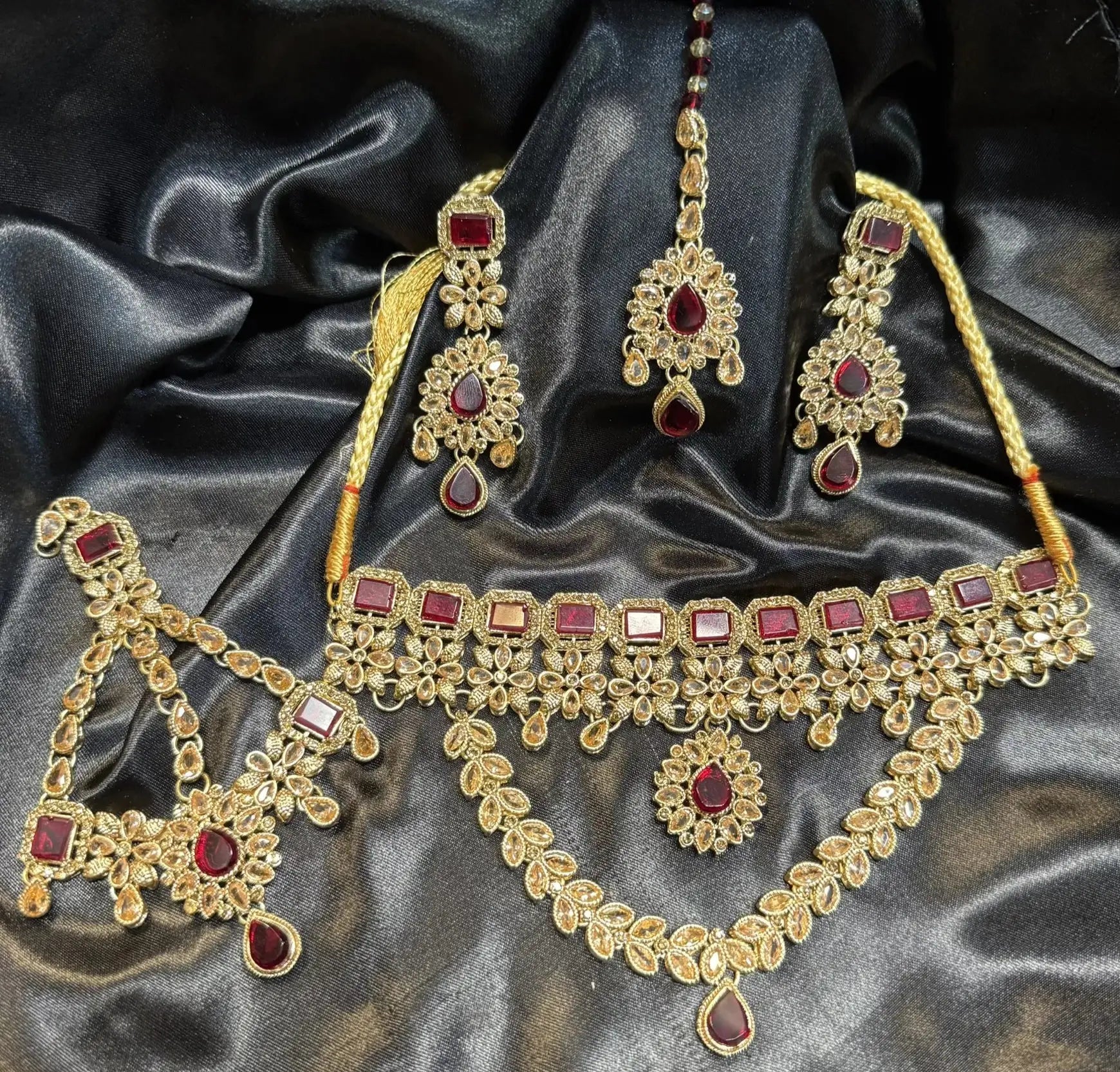 Handmade gold-plated Pakistani bridal jewelry set JV49 with maroon stones, including choker necklace, earrings, teeka, and jhoomer