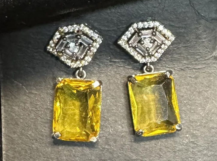 Pair of yellow gemstone earrings on a gray background