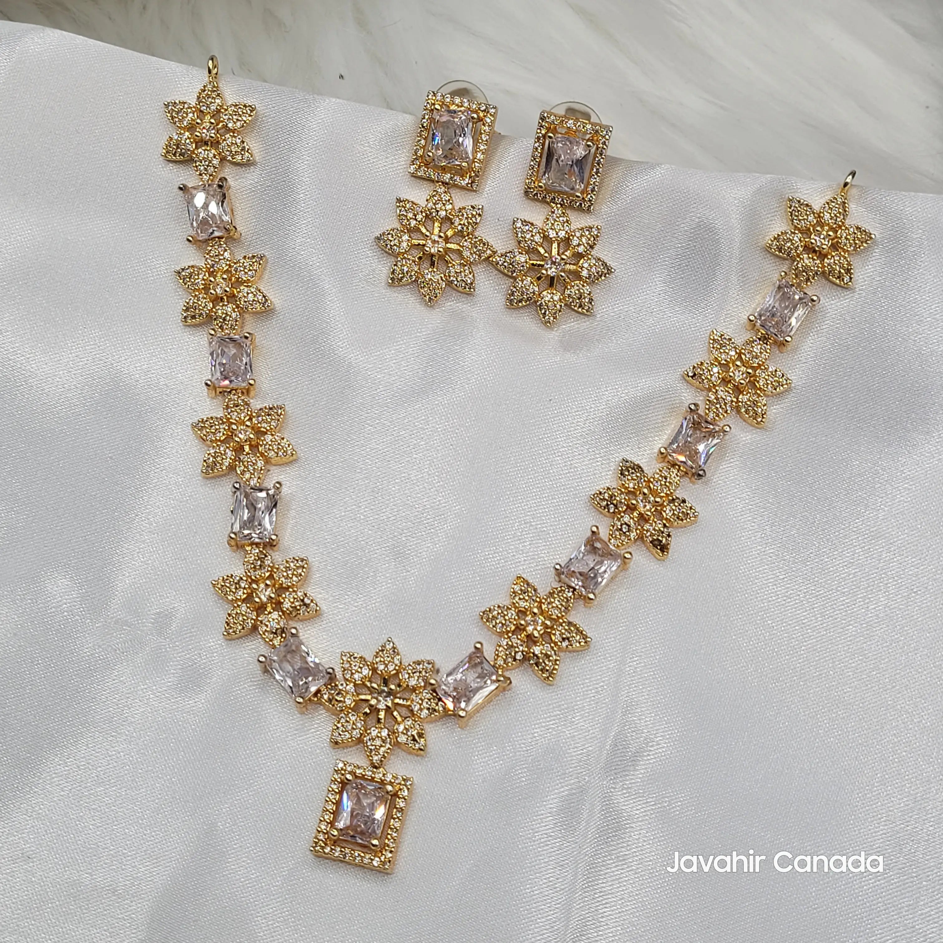 JV146 gold-plated floral necklace and earrings set with champagne CZ stones on a white fabric background with 'Javahir Canada' branding.