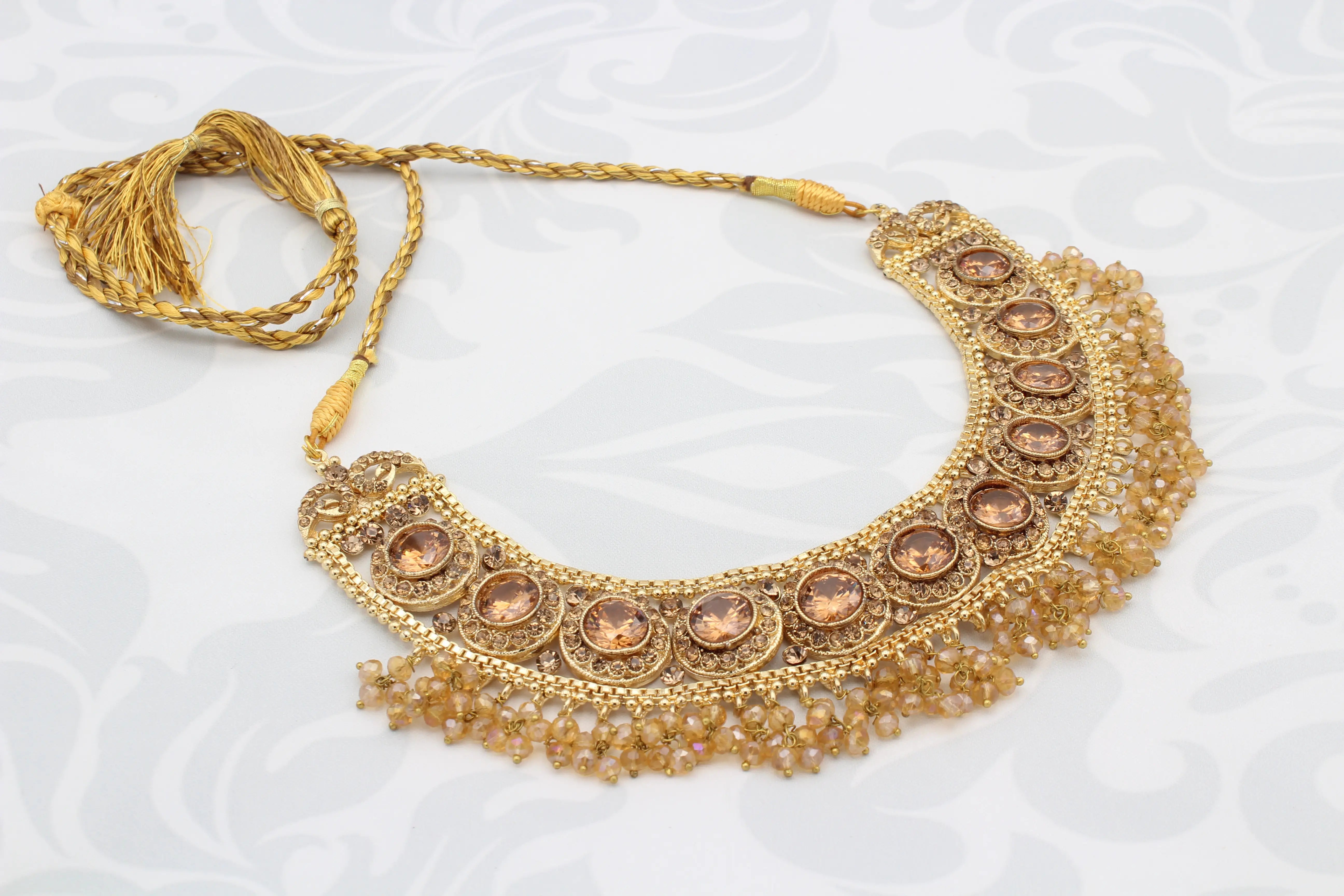 Manjoos Necklace with champagne-toned stones and golden bead fringe on a white background