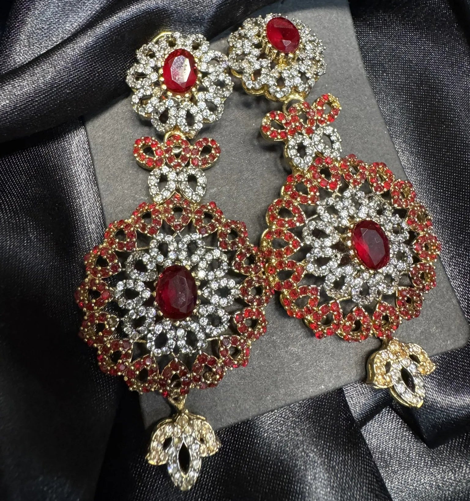 Earrings with maroon gemstones and black background