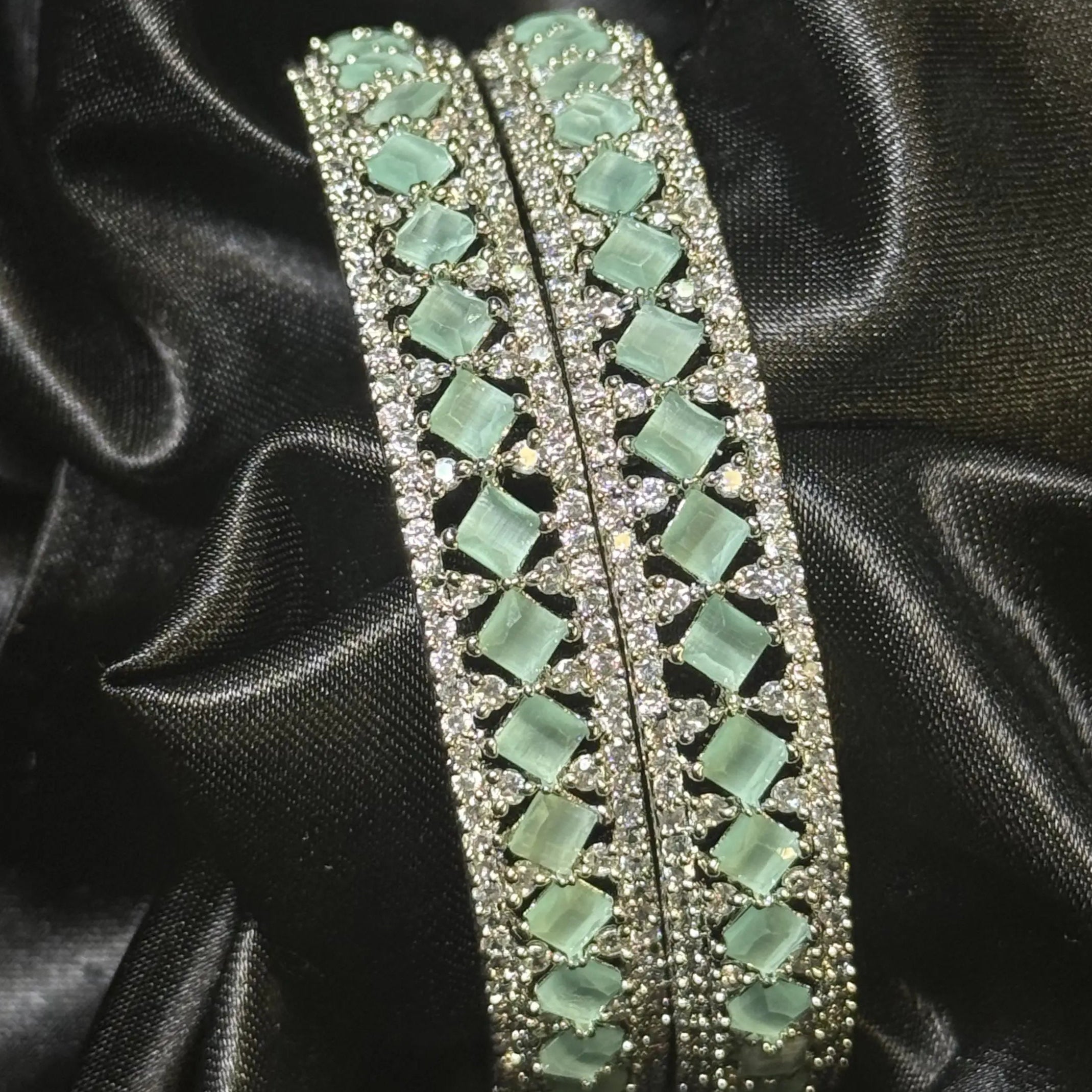 Formal silver bangle pair with teal gemstone design