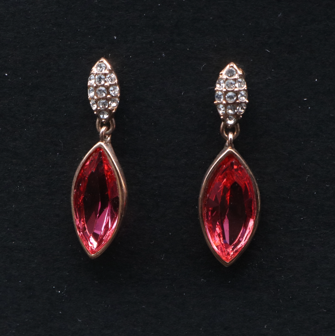 A pair of gold-plated stainless steel earrings with a red gemstone centerpiece, set with American diamonds.
