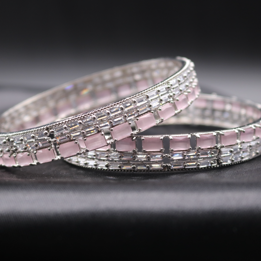 A stainless steel bangles adorned with shimmering American diamonds and pink gemstones.