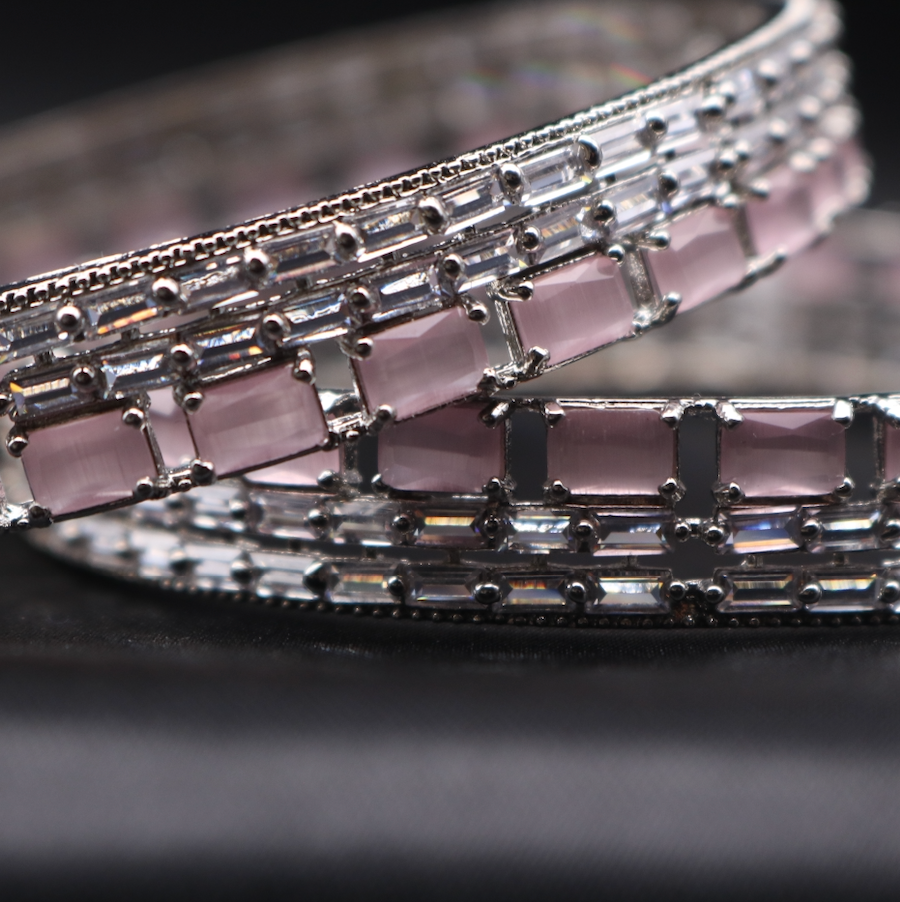 closer view of stainless steel bangles adorned with shimmering American diamonds and pink gemstones.