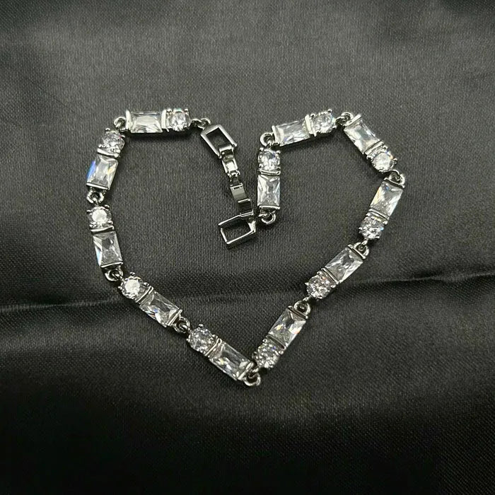 Silver American diamonds bracelet with clear stones on a dark fabric background