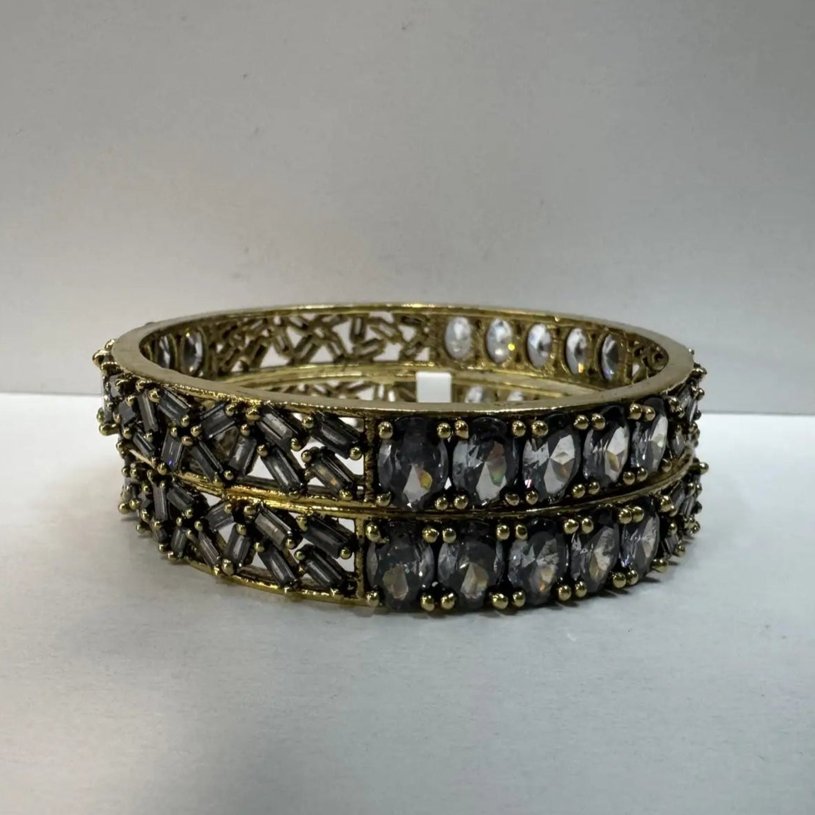Pair of gold and black beaded bangles with gemstones