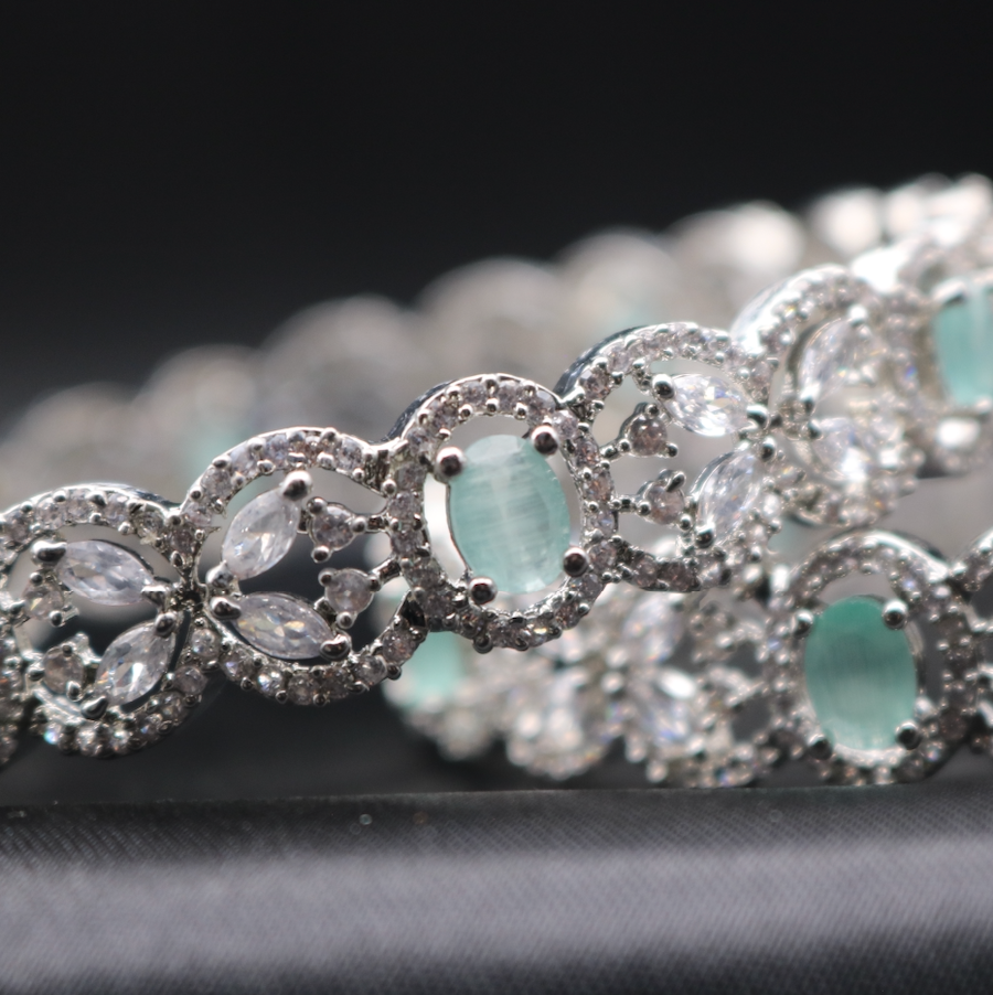 closer view of American diamonds stainless steel bangles with teal and clear gemstones