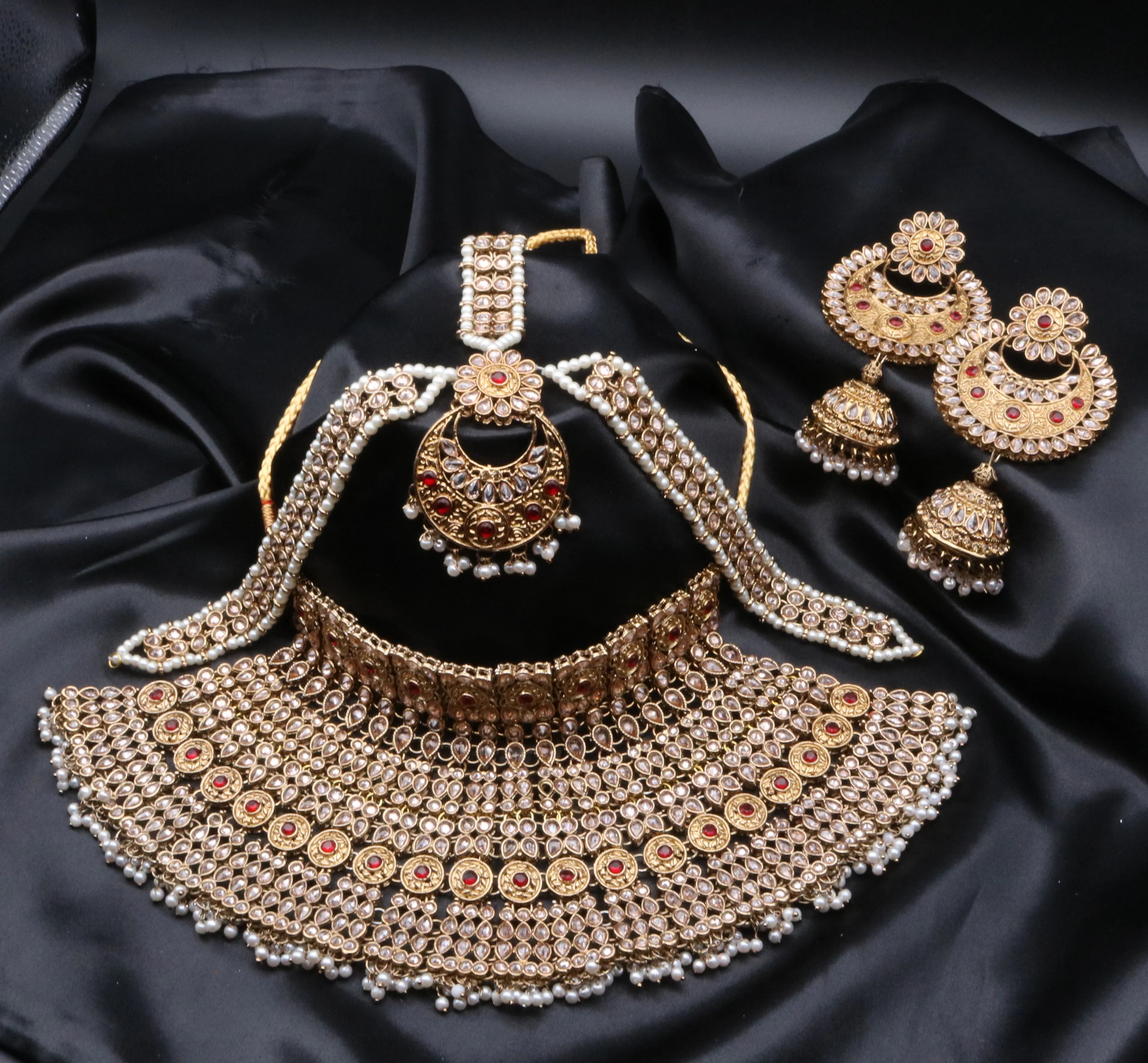 A traditional Pakistani style bridal set with gold-plated and waterproof qualities on a black silk background