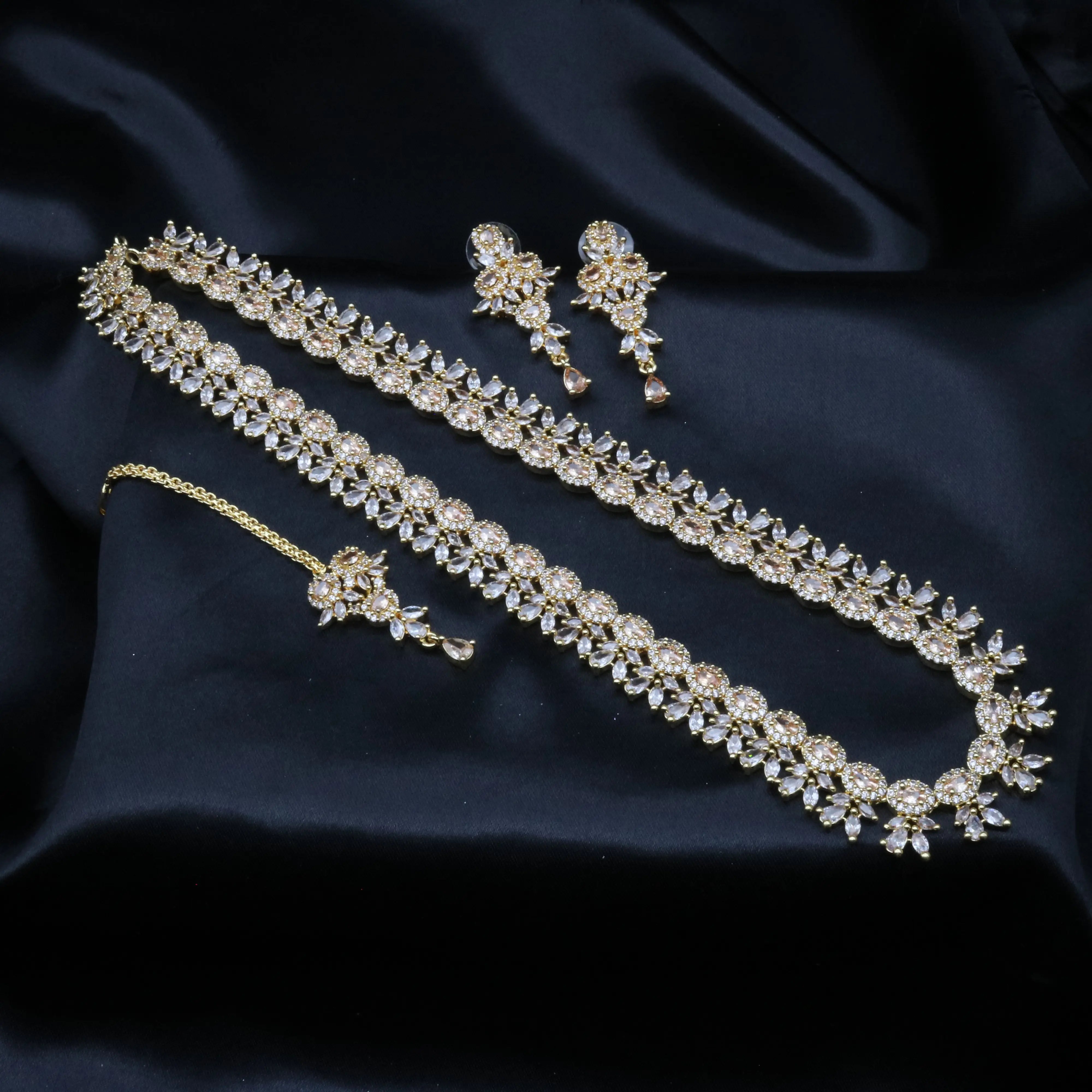 Full Royalty necklace set including necklace, earrings, and teeka laid out on black satin background