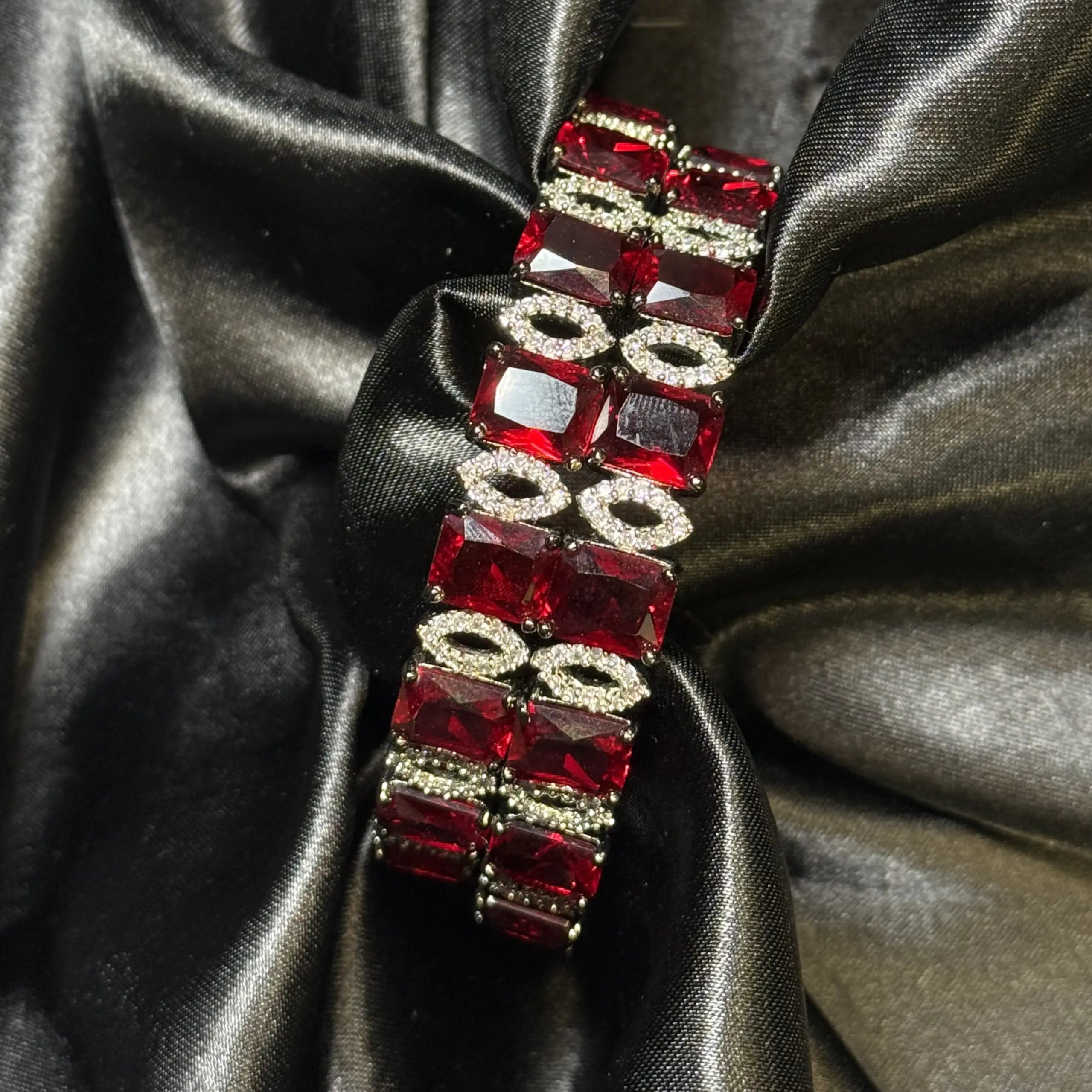 Ruby red American diamond bangle on black satin background