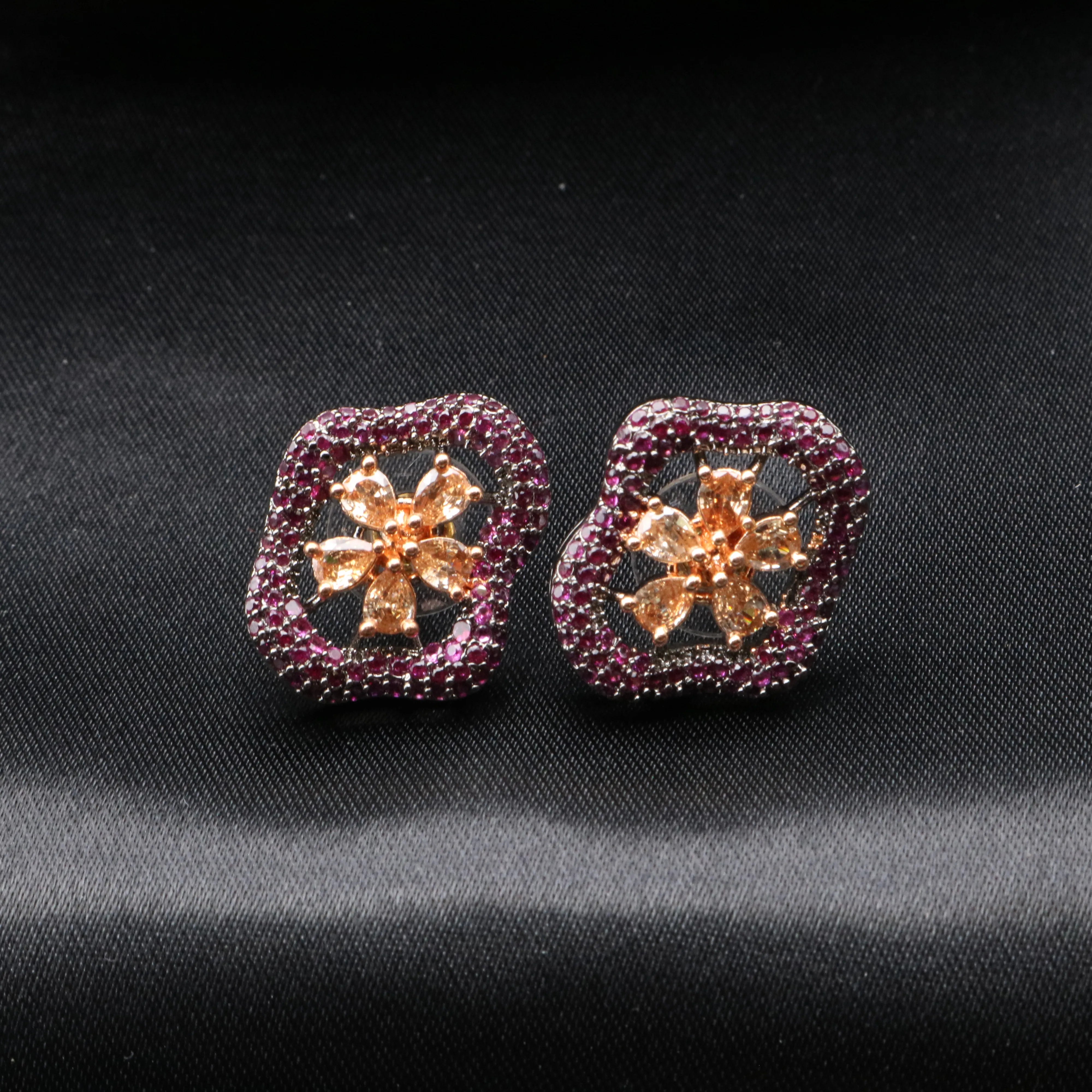 Pair of earrings with floral design on a black background