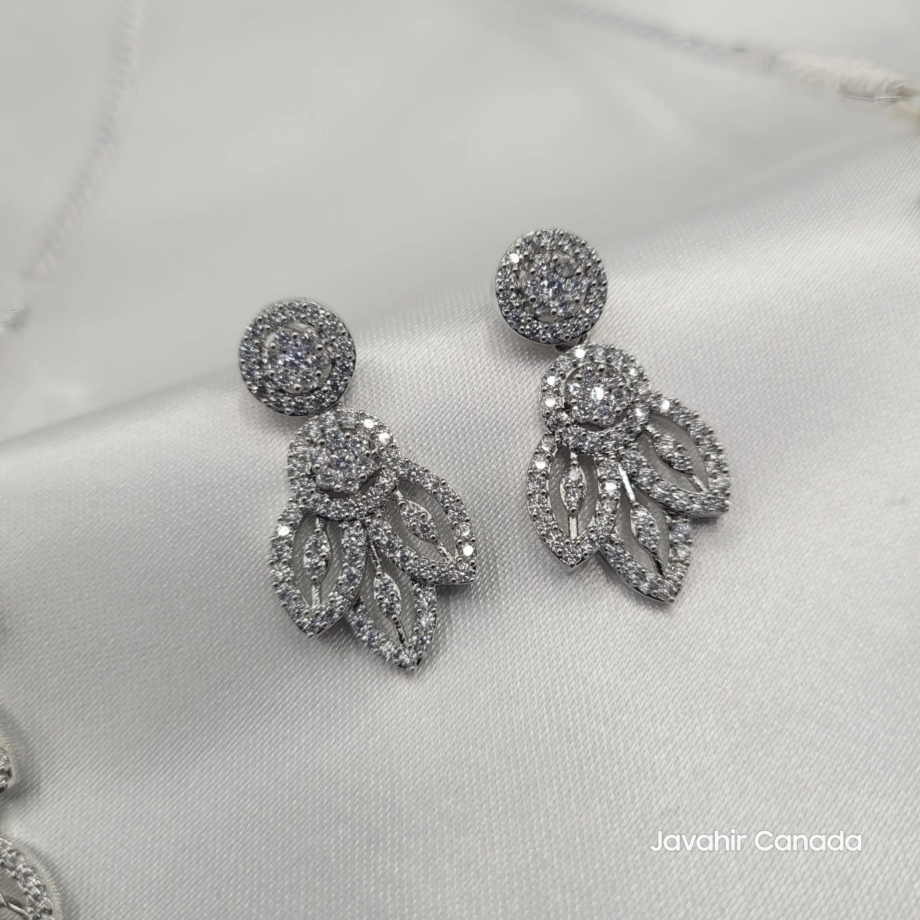 Close-up of Aria matching earrings with round and leaf-shaped CZ stones.