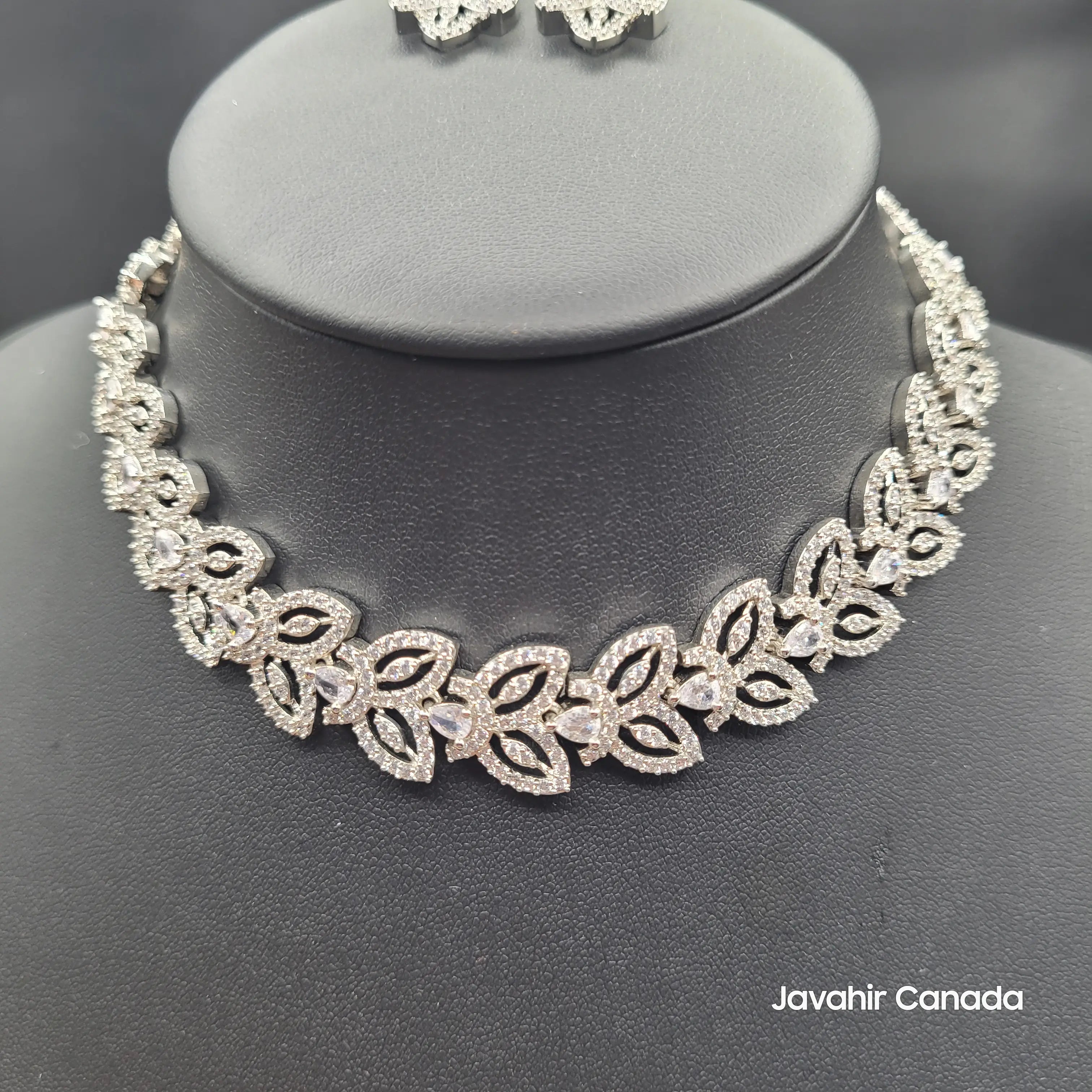 Front view of Aria silver CZ necklace on a display stand showing leaf pattern design.