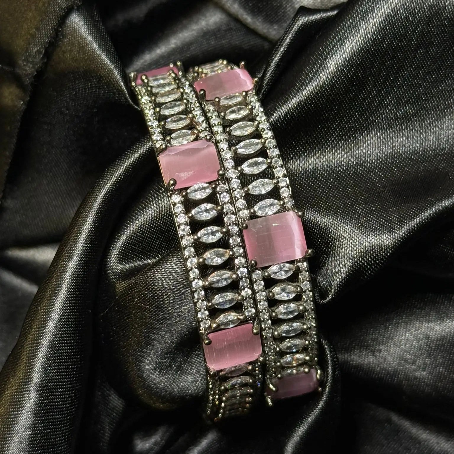 Pink and silver American diamond statement bangle on black satin
