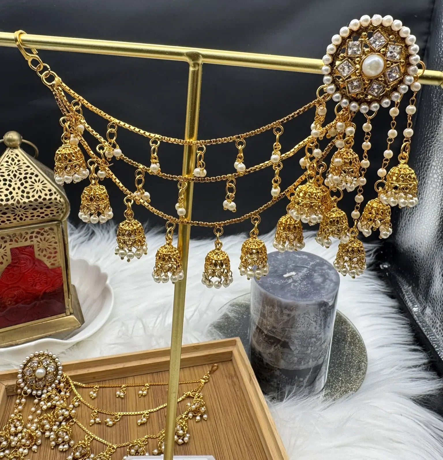 A pair of stainless steel and gold plated jhumka style earrings  with intricate saharas and hanging details.