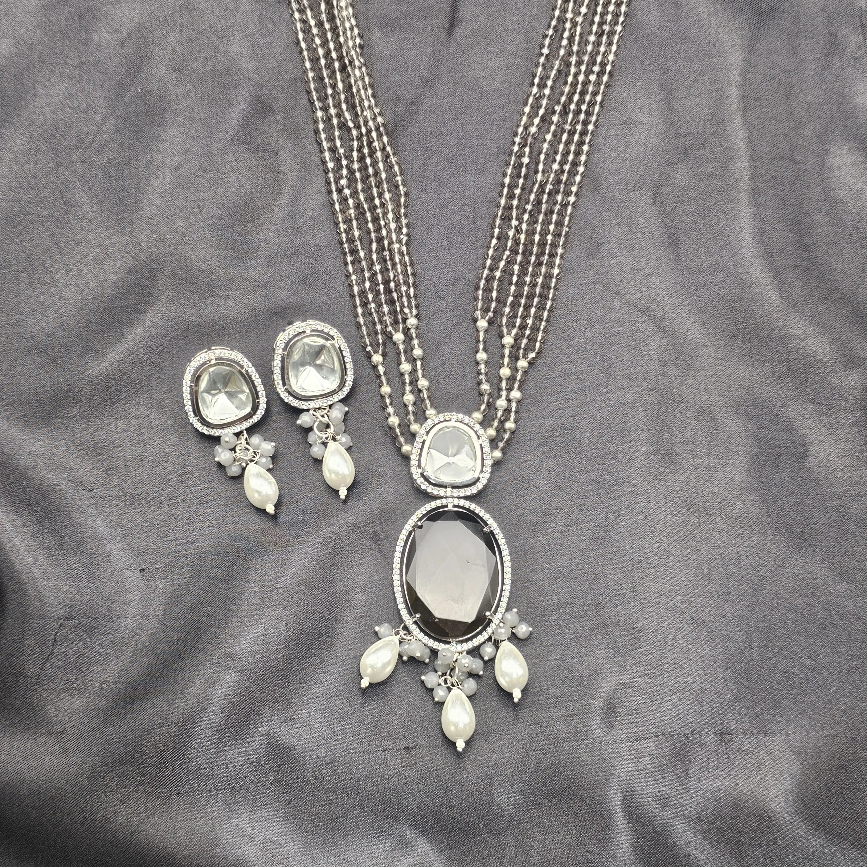 Flat lay of the smoky grey Caspian necklace set with beaded layers and faux Kundan stones.