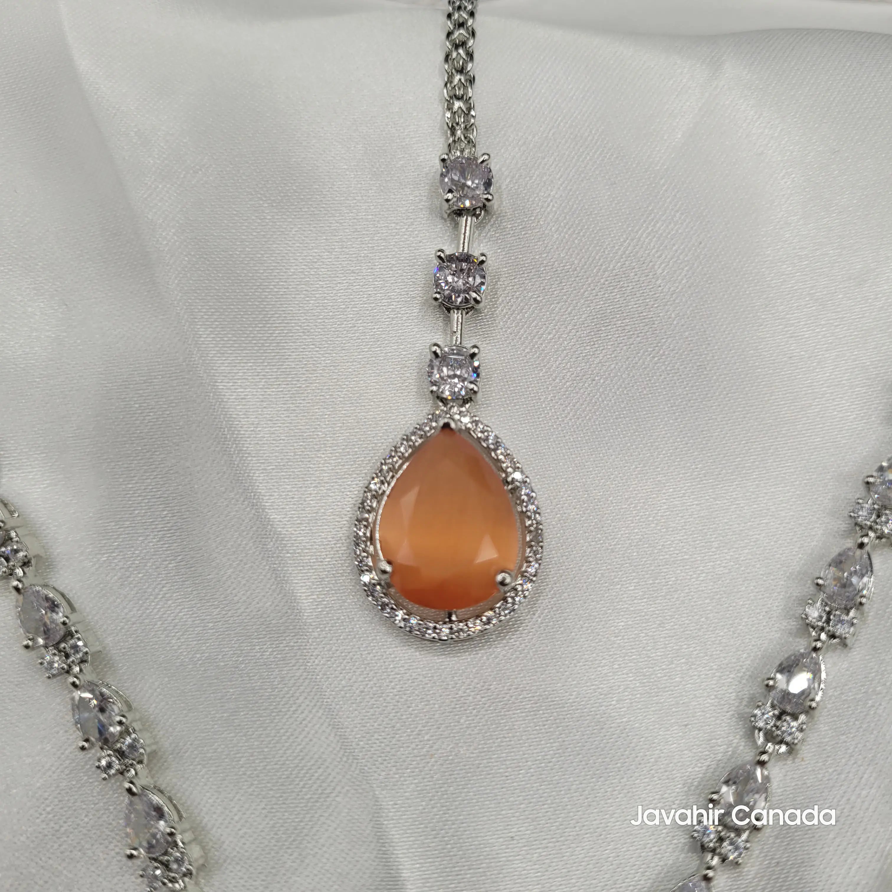 Orange gemstone pendant on stainless steel chain surrounded by sparkling cubic zirconia.