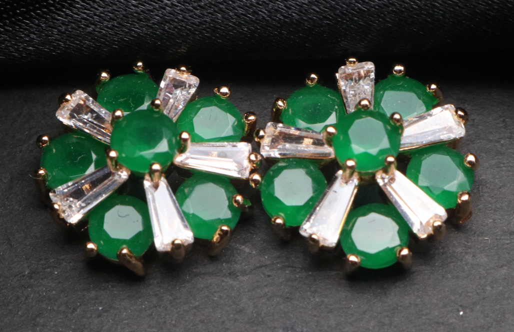 Pair of green gemstone earrings with silver accents on a dark fabric background. Waterproof and anti-tarnish