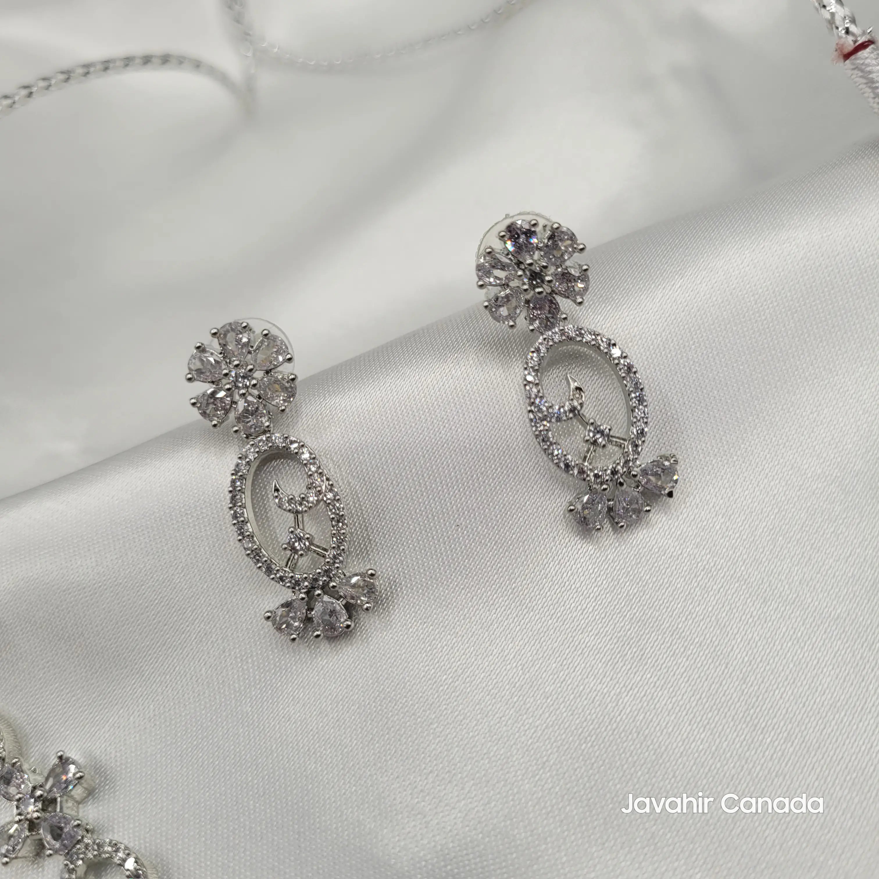 Pair of earrings in silver CZ with elegant floral design.