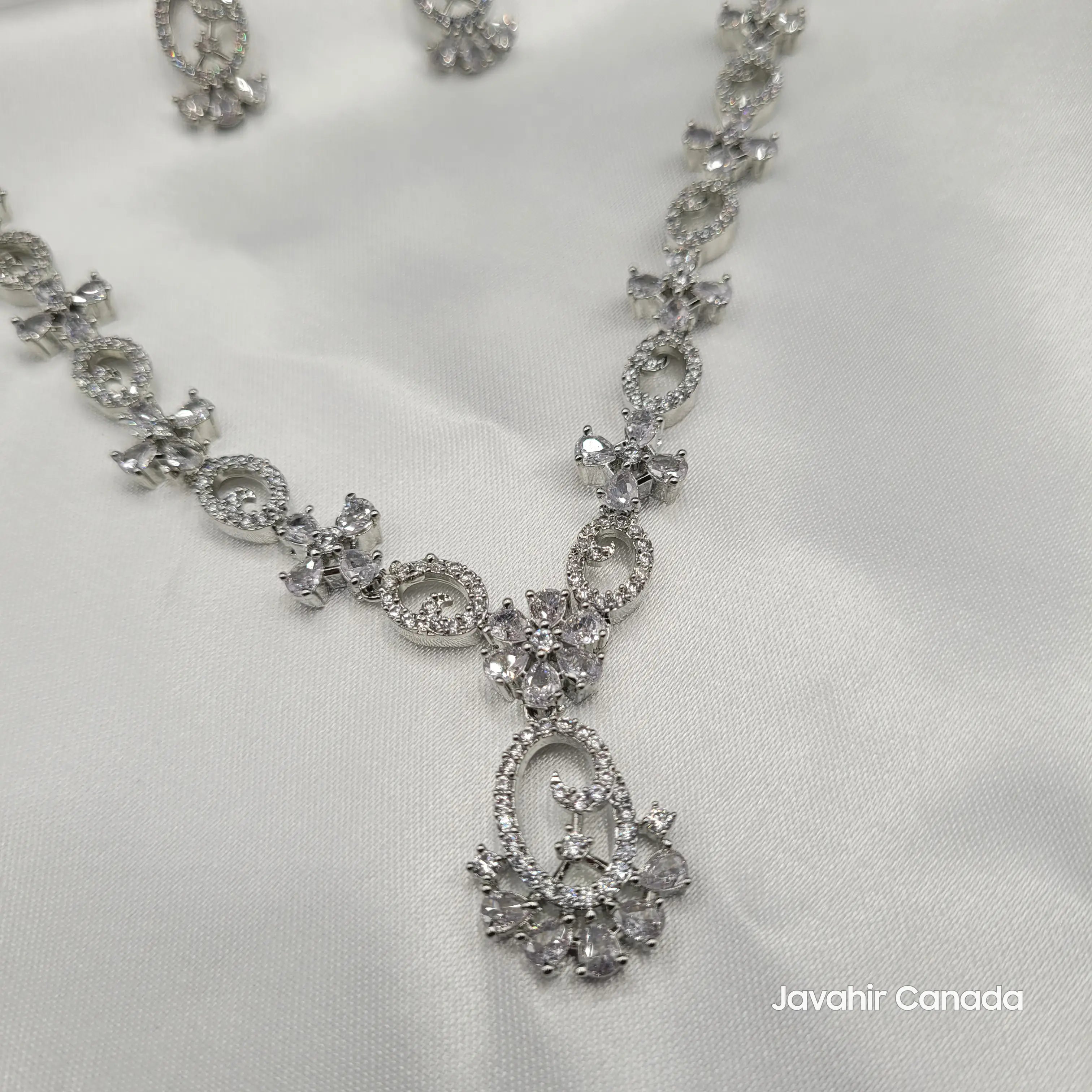Close-up of clear silver CZ necklace pendant with round and pear-shaped stones.