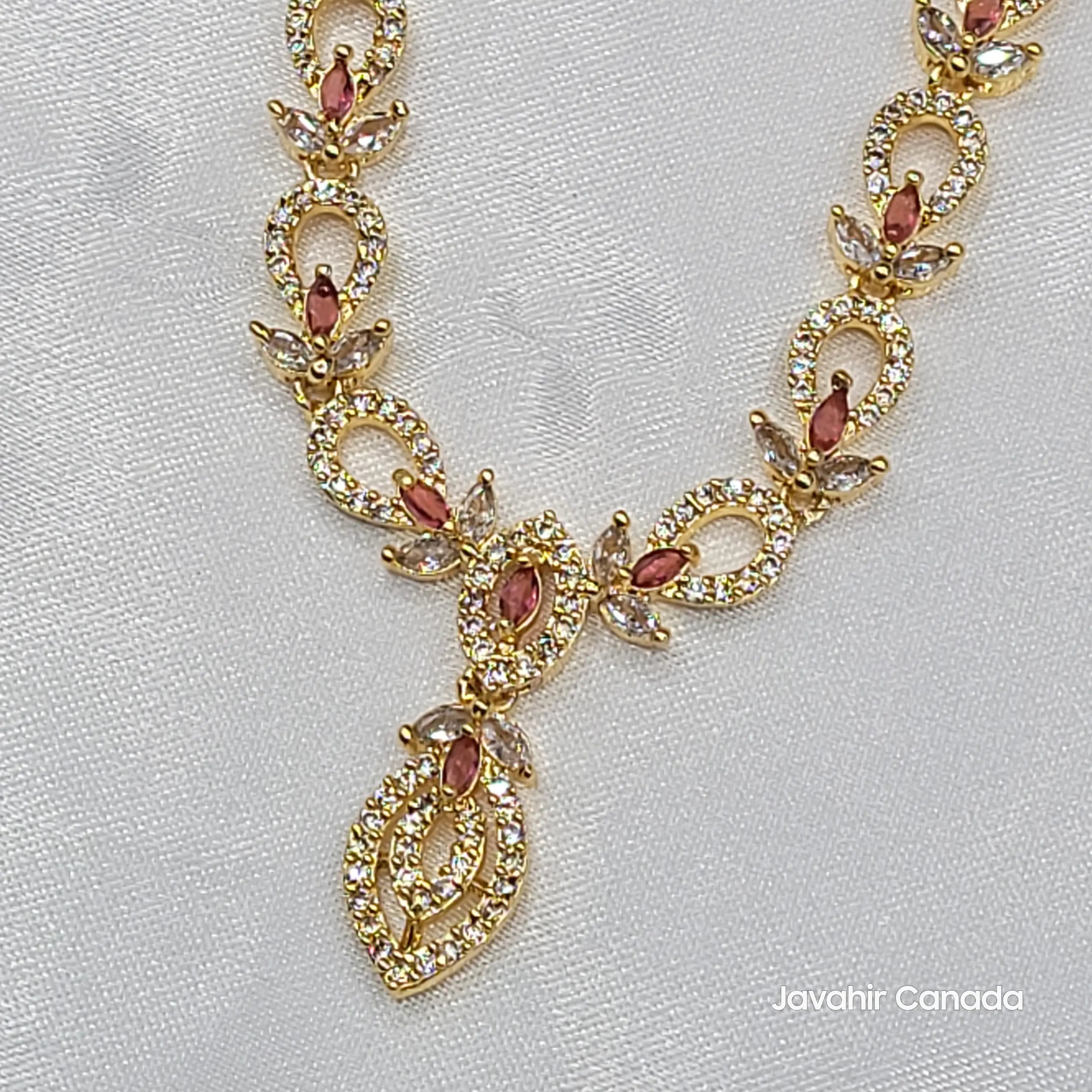 Close-up of Cove necklace showing rose red marquise CZ stones in a gold-plated setting.