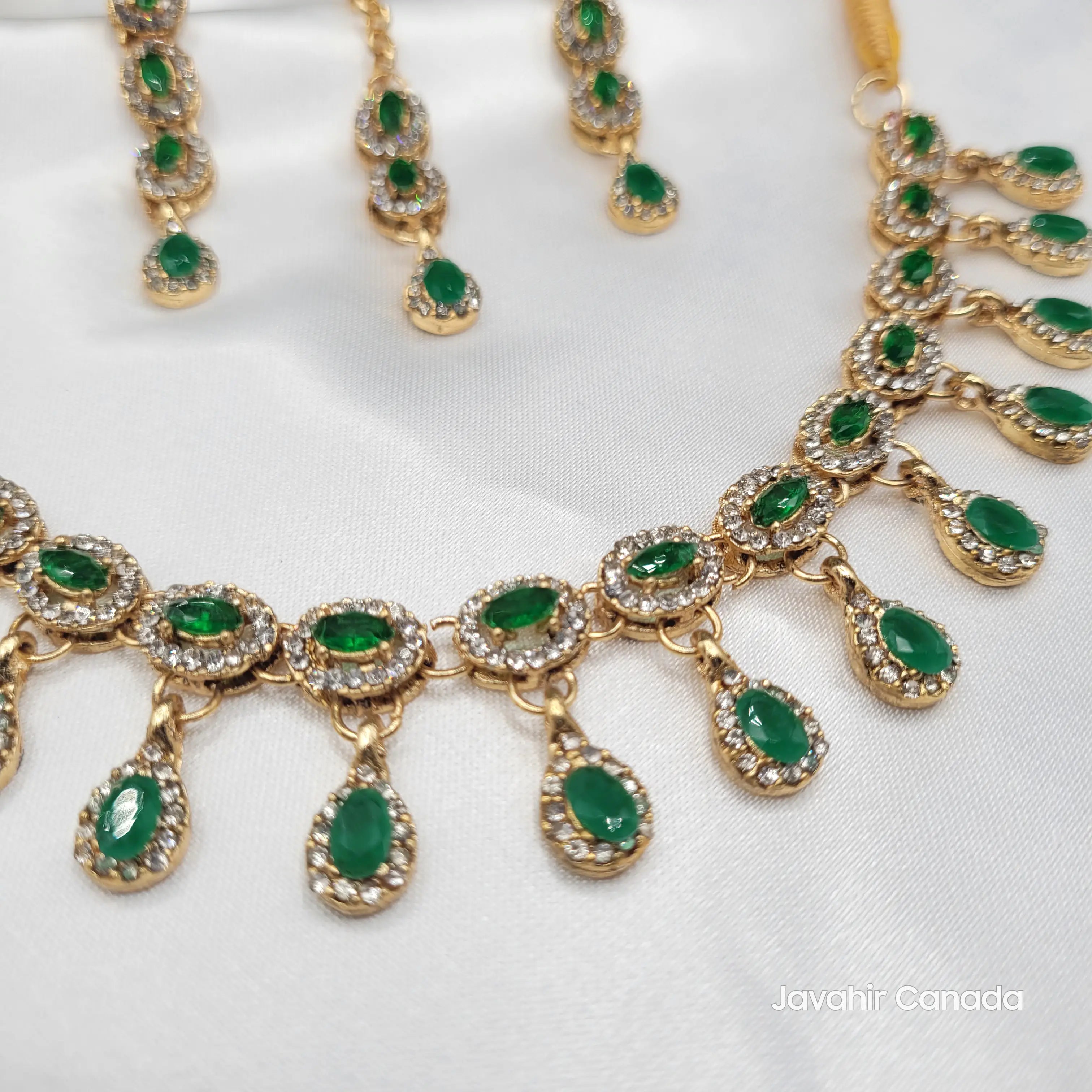 Close-up of emerald green Daint necklace with teardrop CZ and American diamonds in gold plating