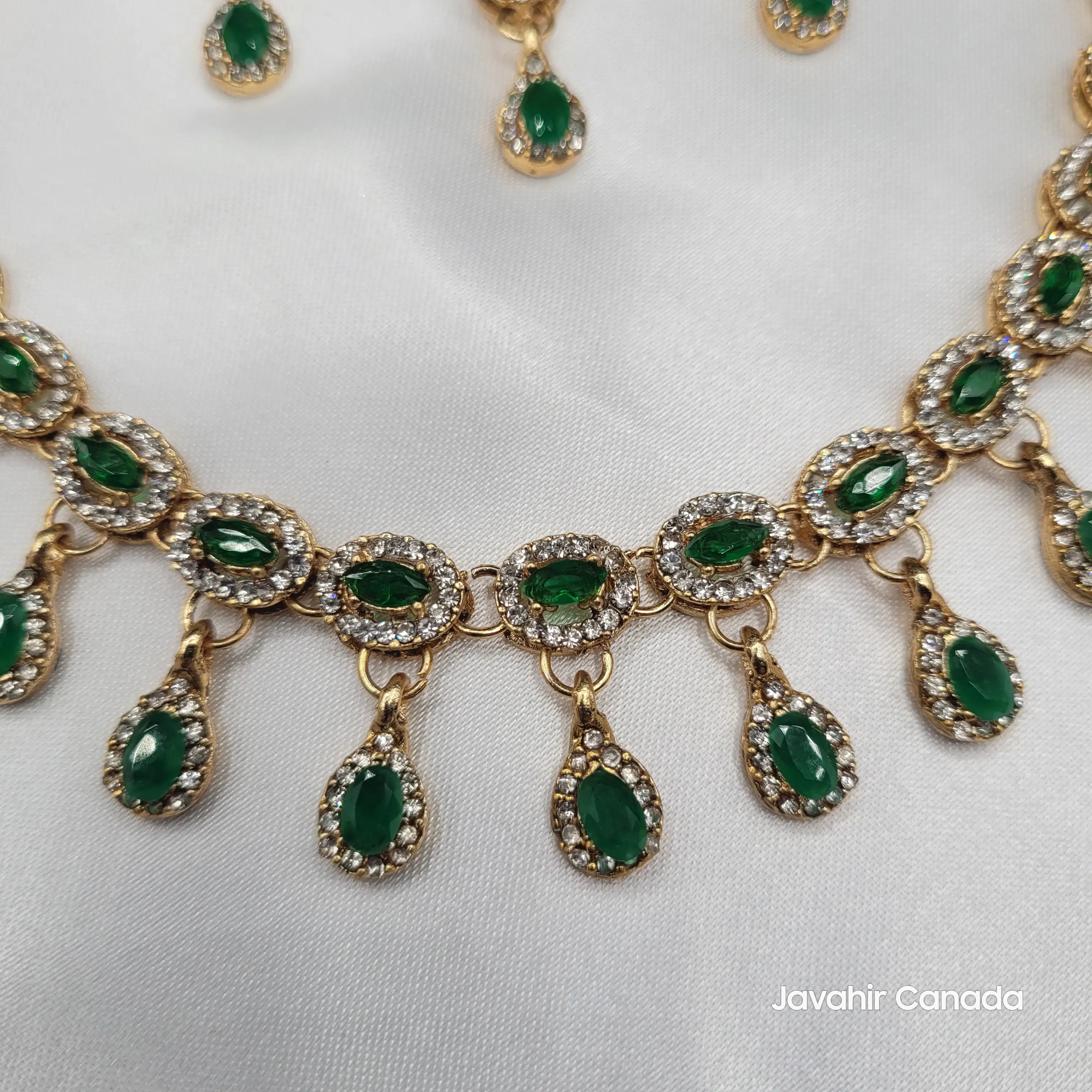 Detailed shot of necklace stones and hanging elements with green CZ and American diamonds