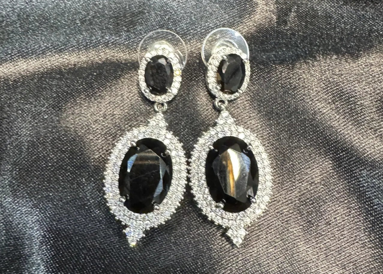 Black teardrop earrings with clear American diamonds on a black satin backgrounds 