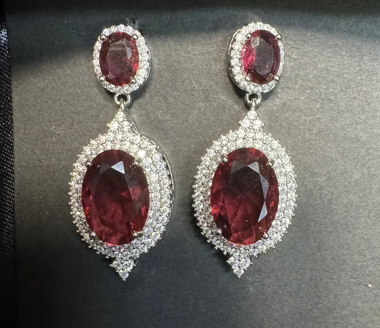 Pair of earrings with red gemstones on a black background