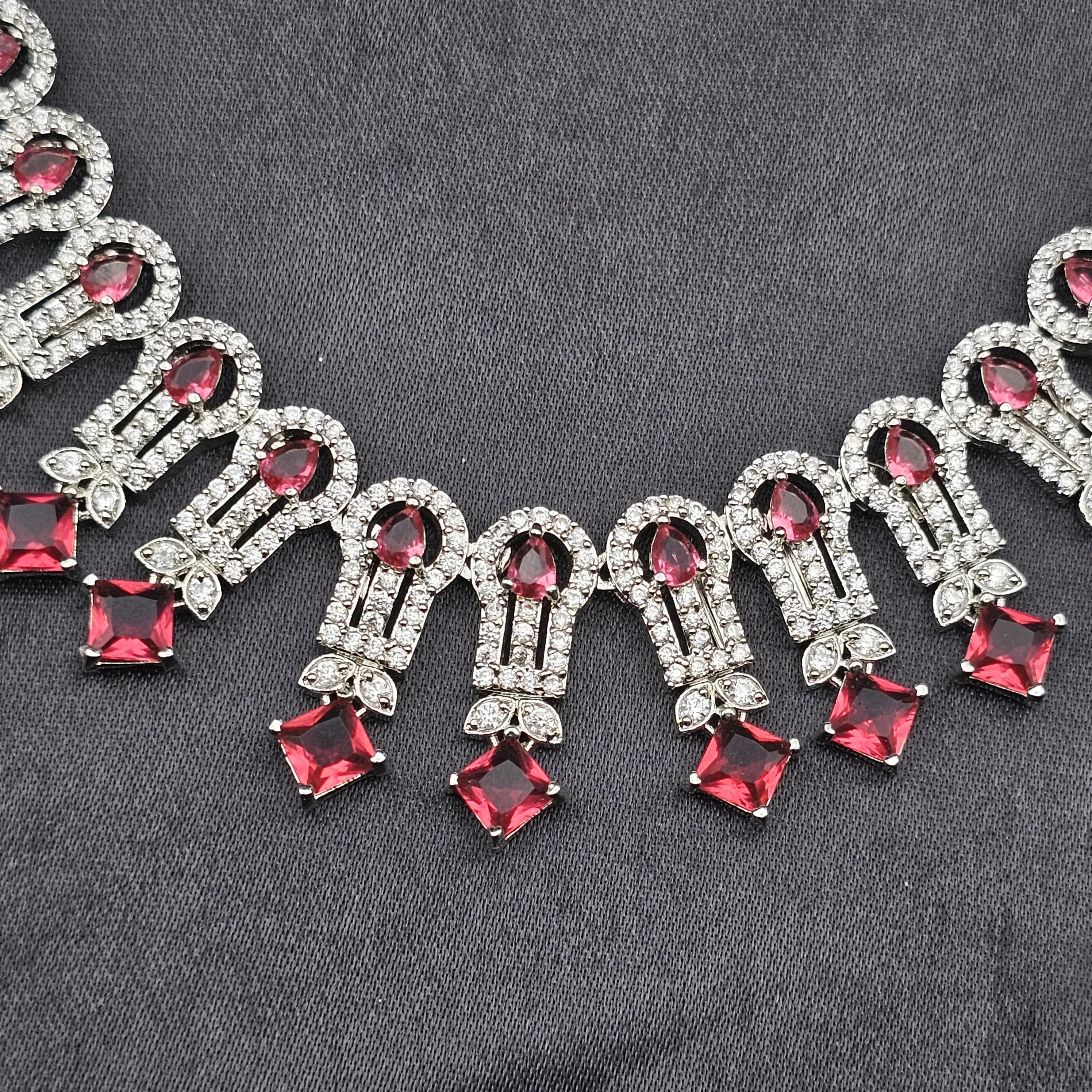 Close-up of the Euphoric necklace featuring ruby red square and teardrop CZ stones with American diamond detailing.