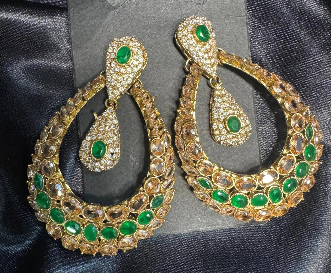 Handcrafted in Pakistan Gold and green earrings on a black satin background