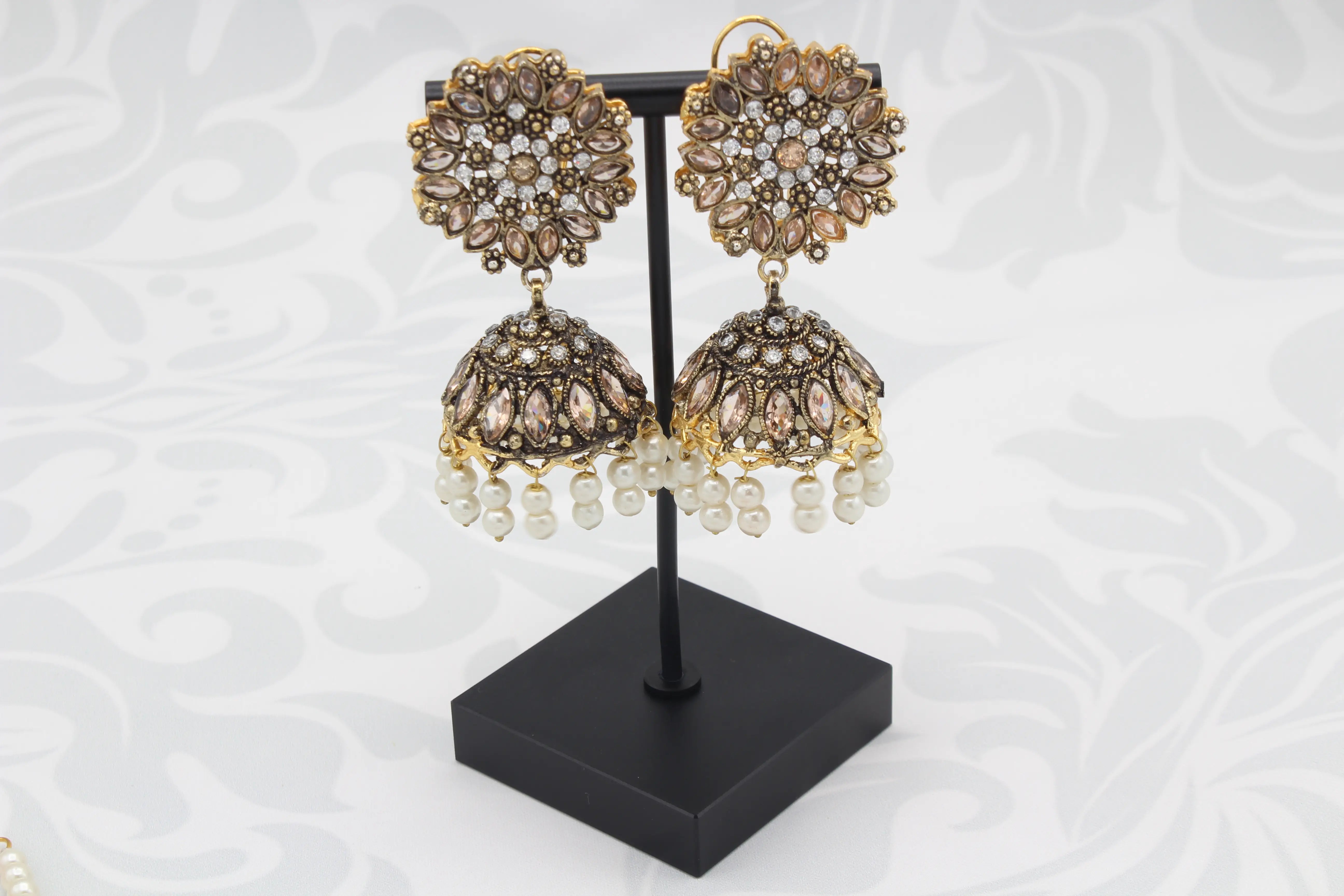 Close-up of floral jhumka earrings with pearl drops
