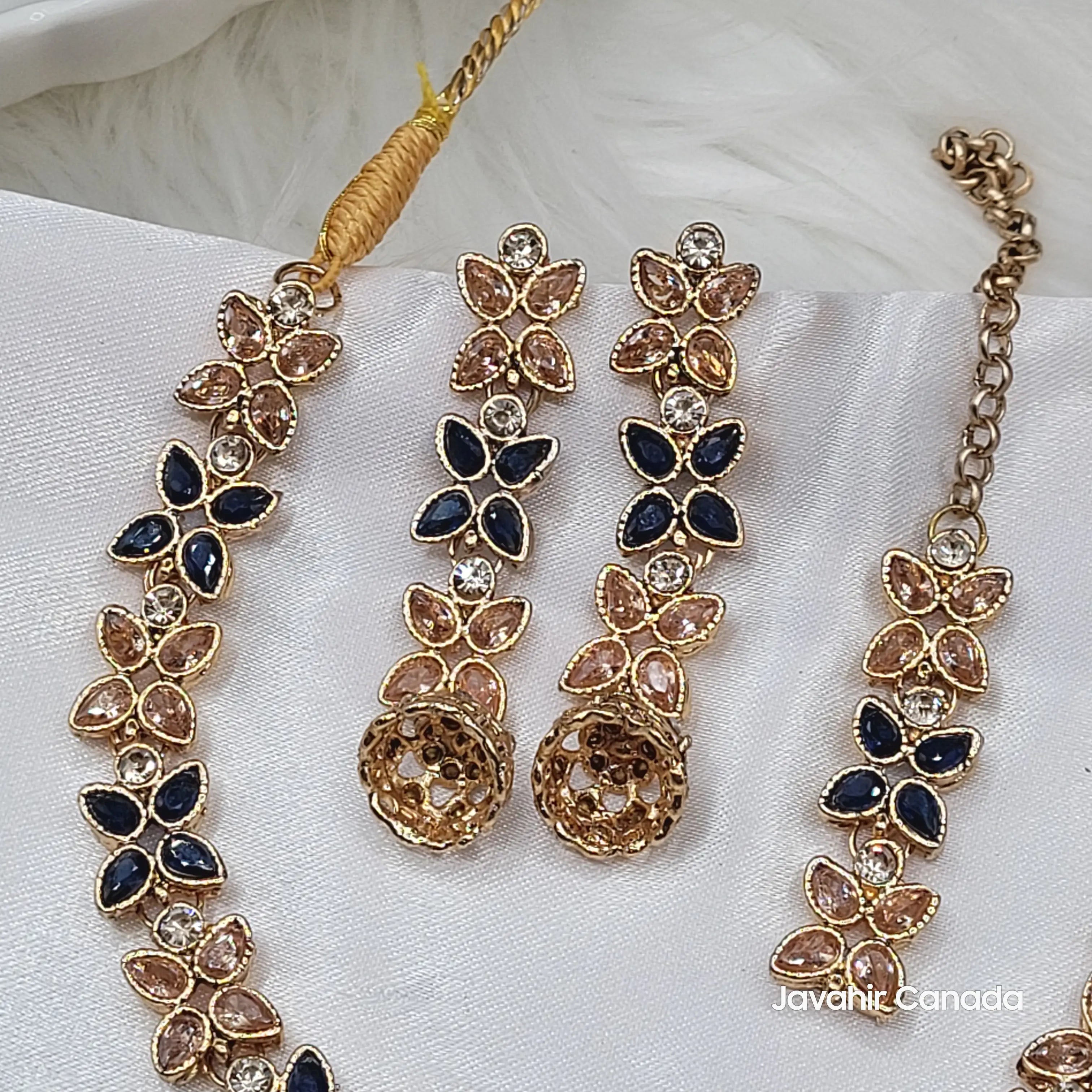 Angled top-down shot of Flora necklace set combining navy and champagne stones with gold base.
