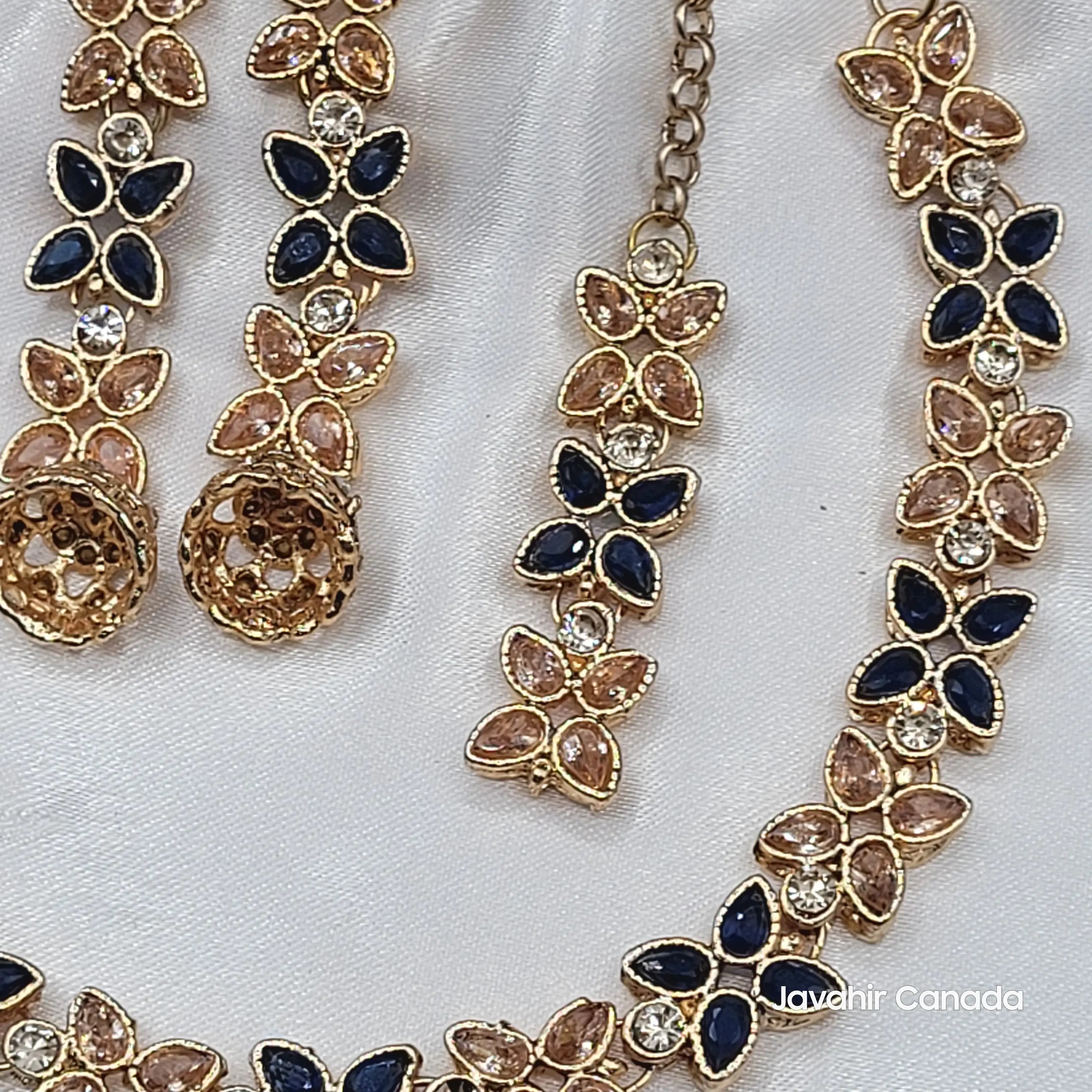Zoomed-in view of Flora necklace and earring details in navy + champagne variant.