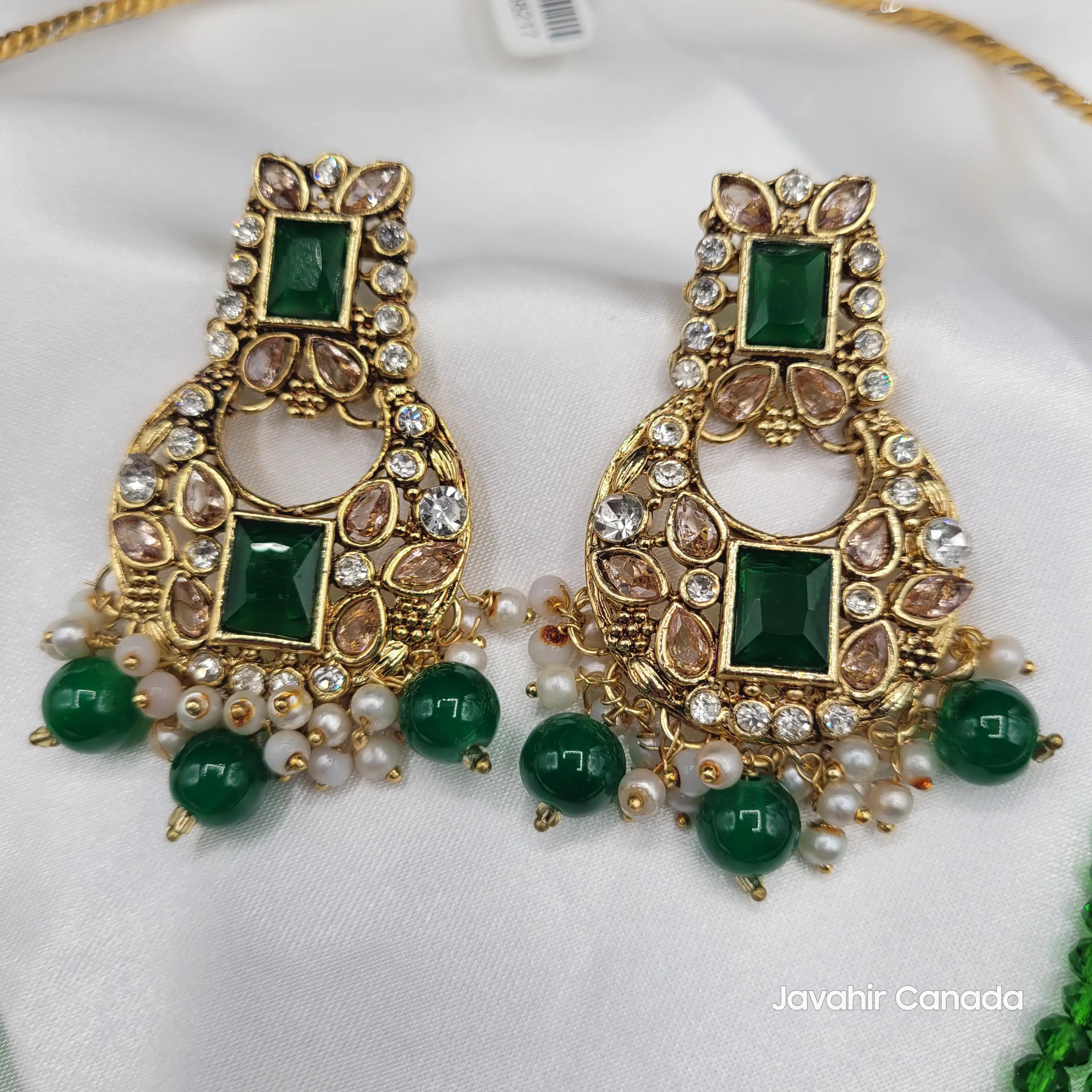 Close-up of emerald green variant earrings with gold base and green drops