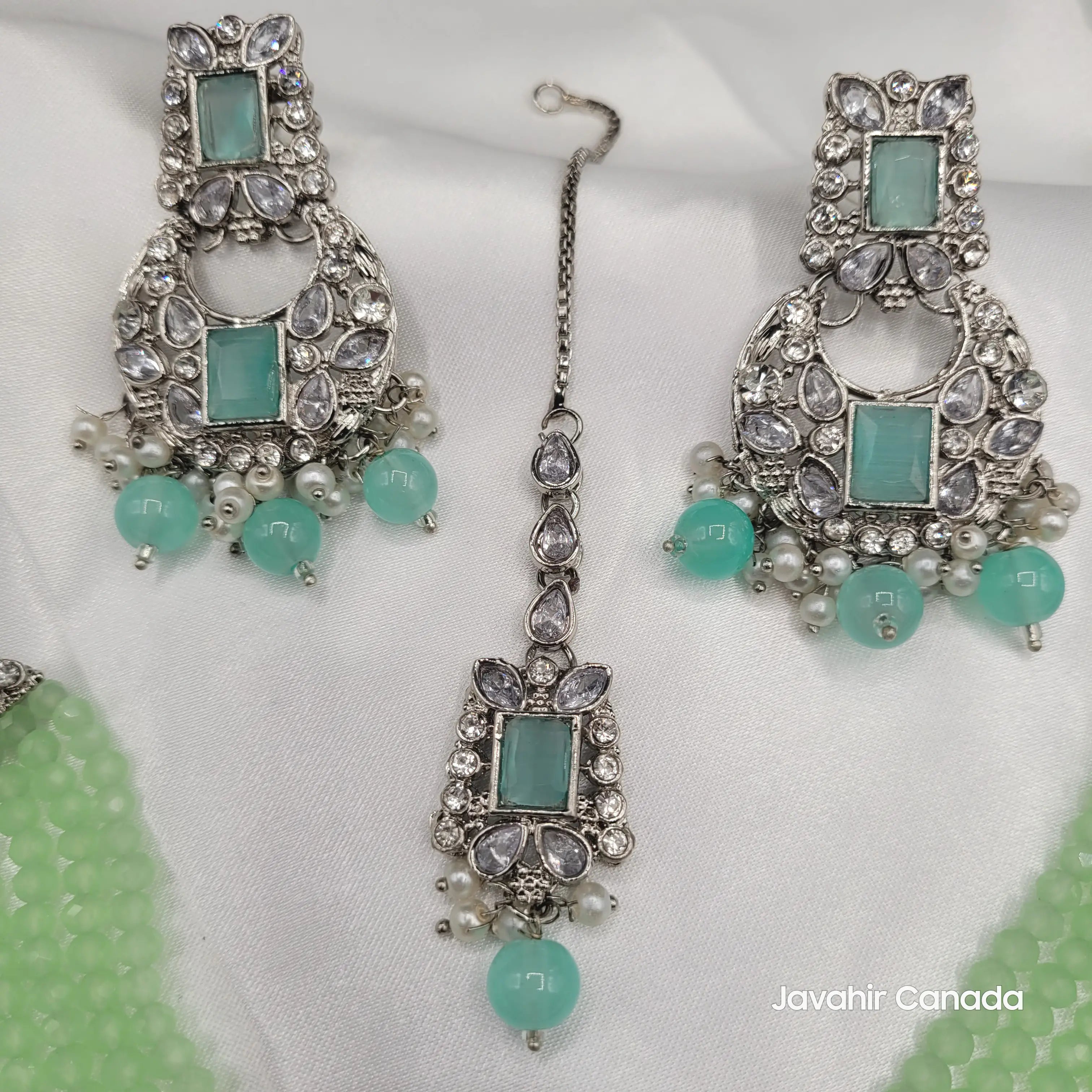 Close-up of Firdous mint green earrings with silver base and aqua gemstone drops.