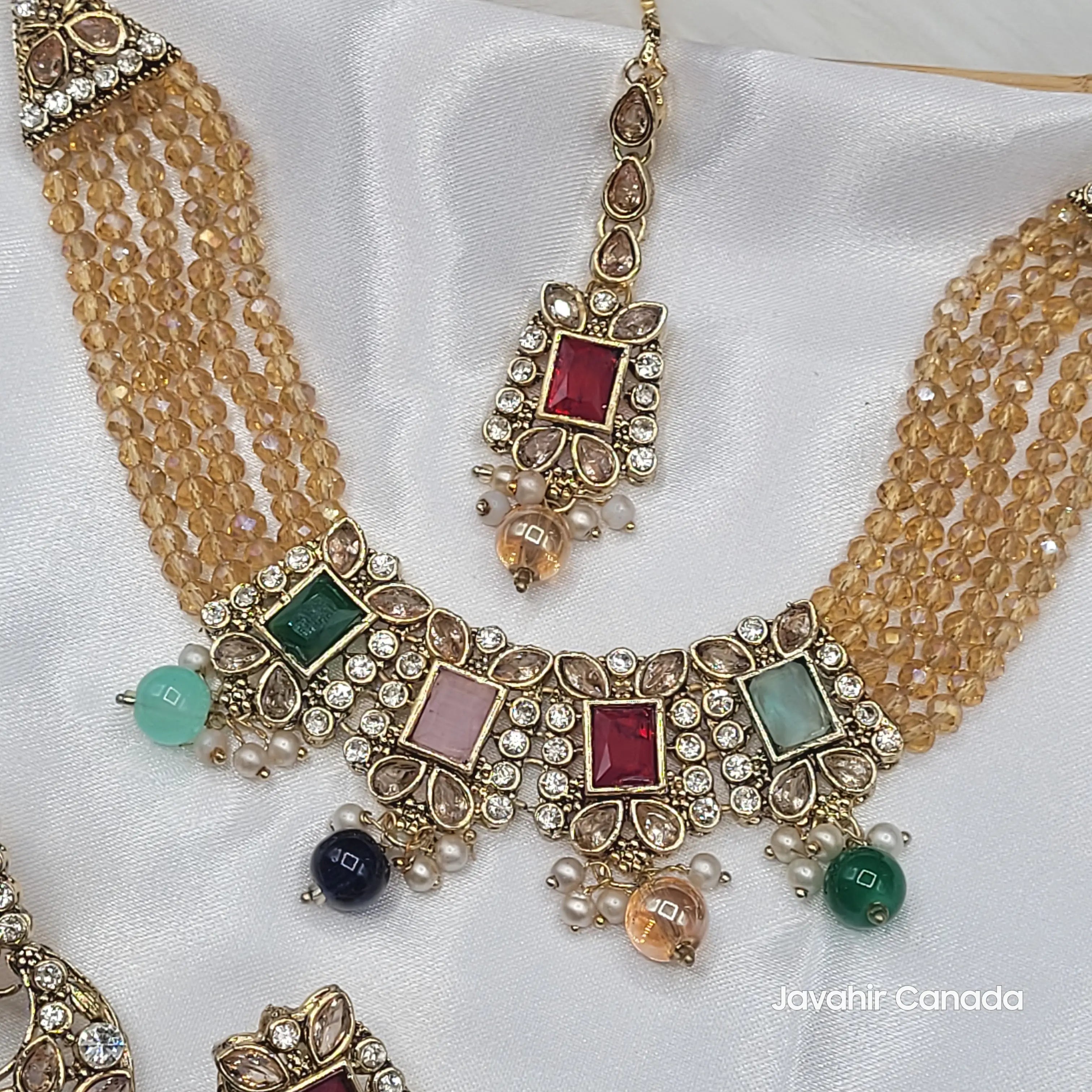 Close-up of multicolor Firdous tikka and stone detailing with golden bead strands