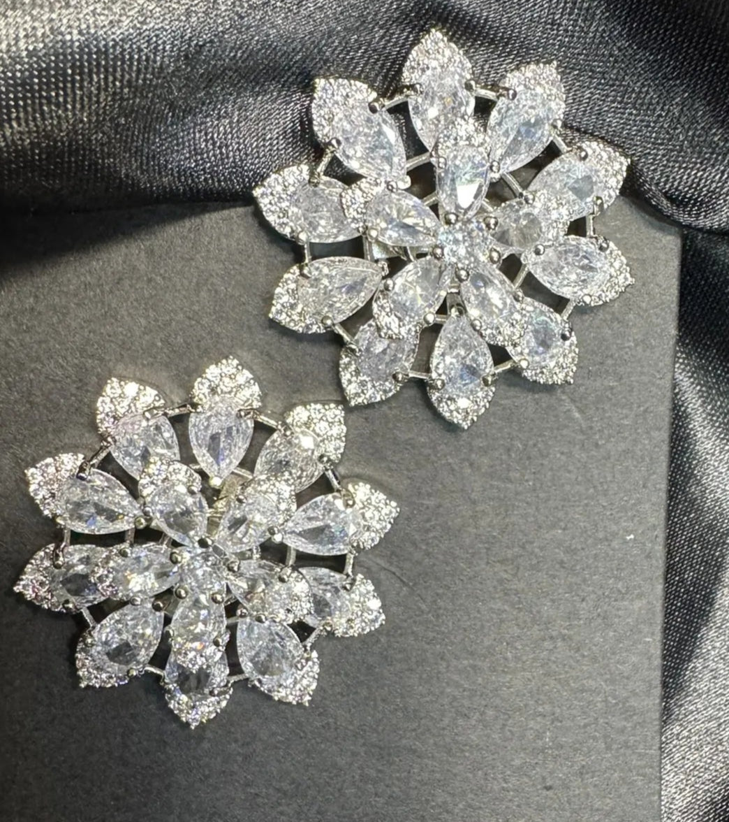 Two sparkling American diamond earrings with a black satin background
