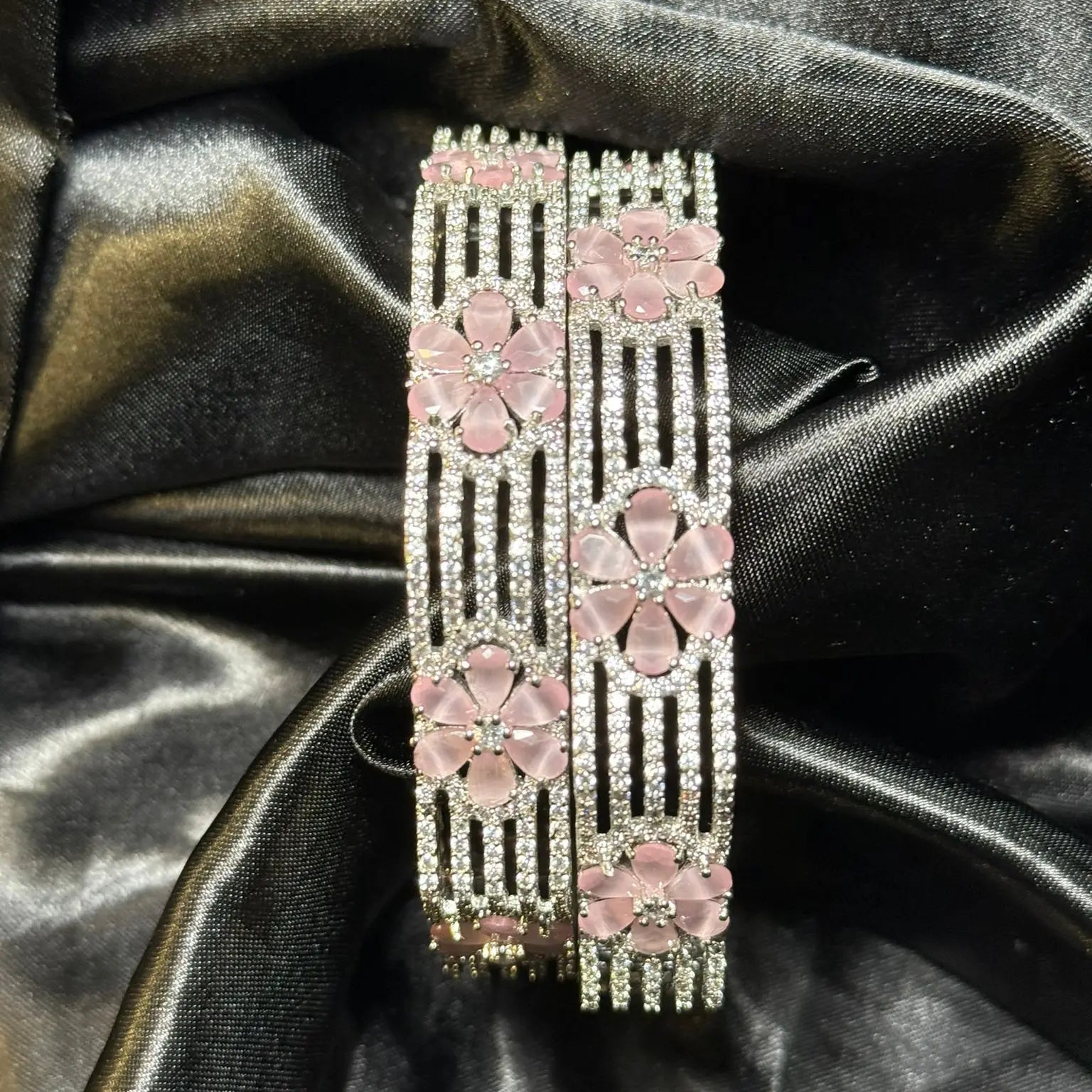Silver and pink floral bangles with crystals on black satin