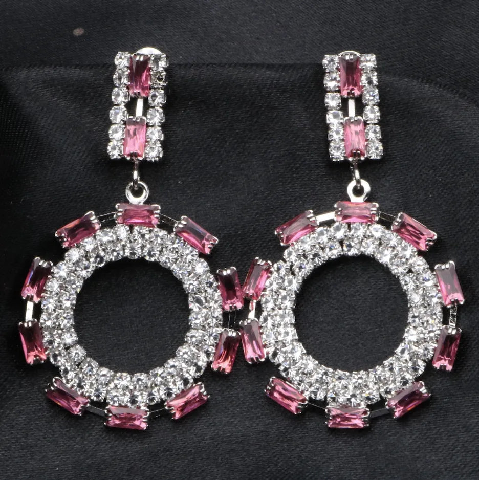 Pair of American diamonds earrings with pink gemstones on a black background