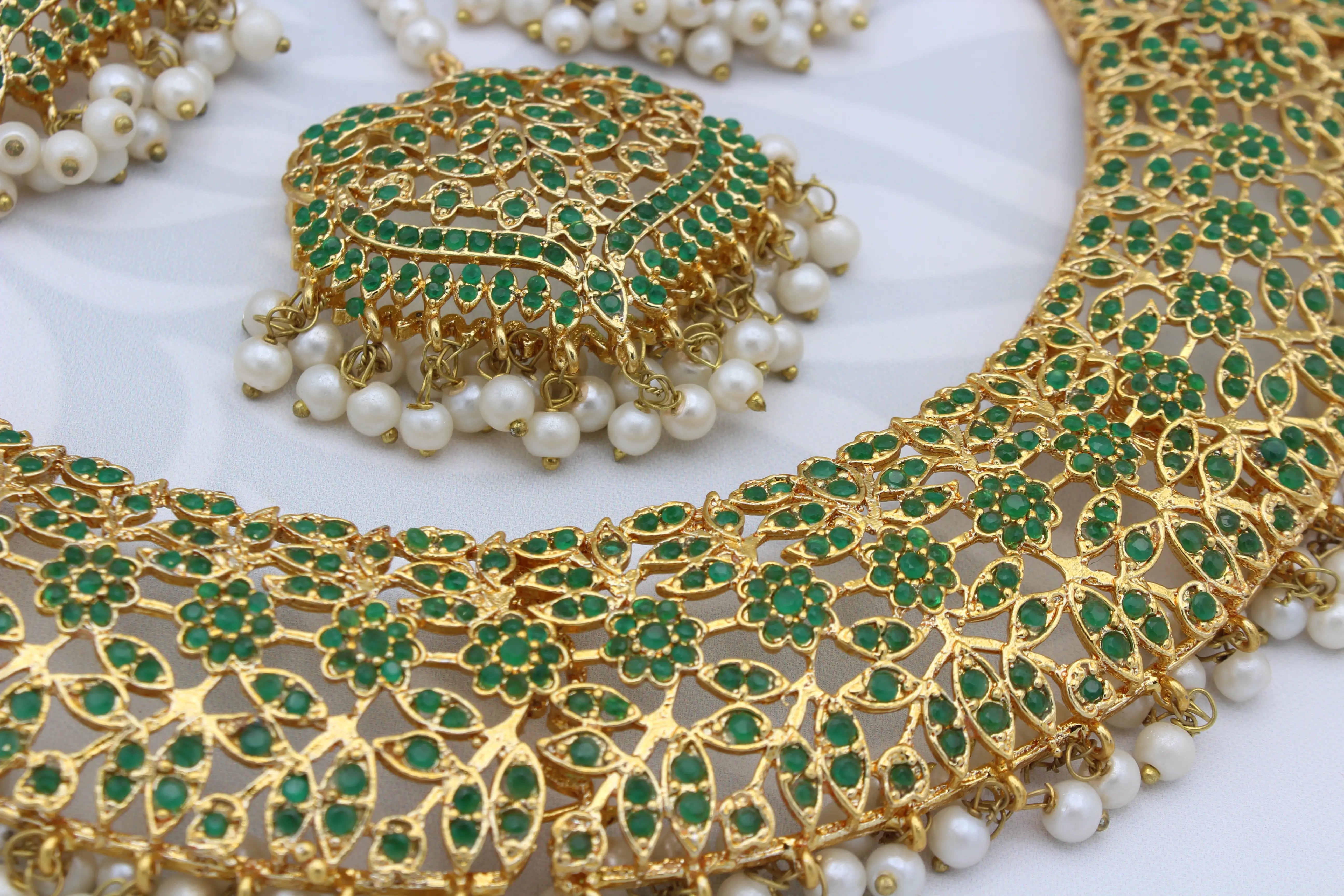 Detailed view of pendant and necklace design with gold floral filigree and pearls