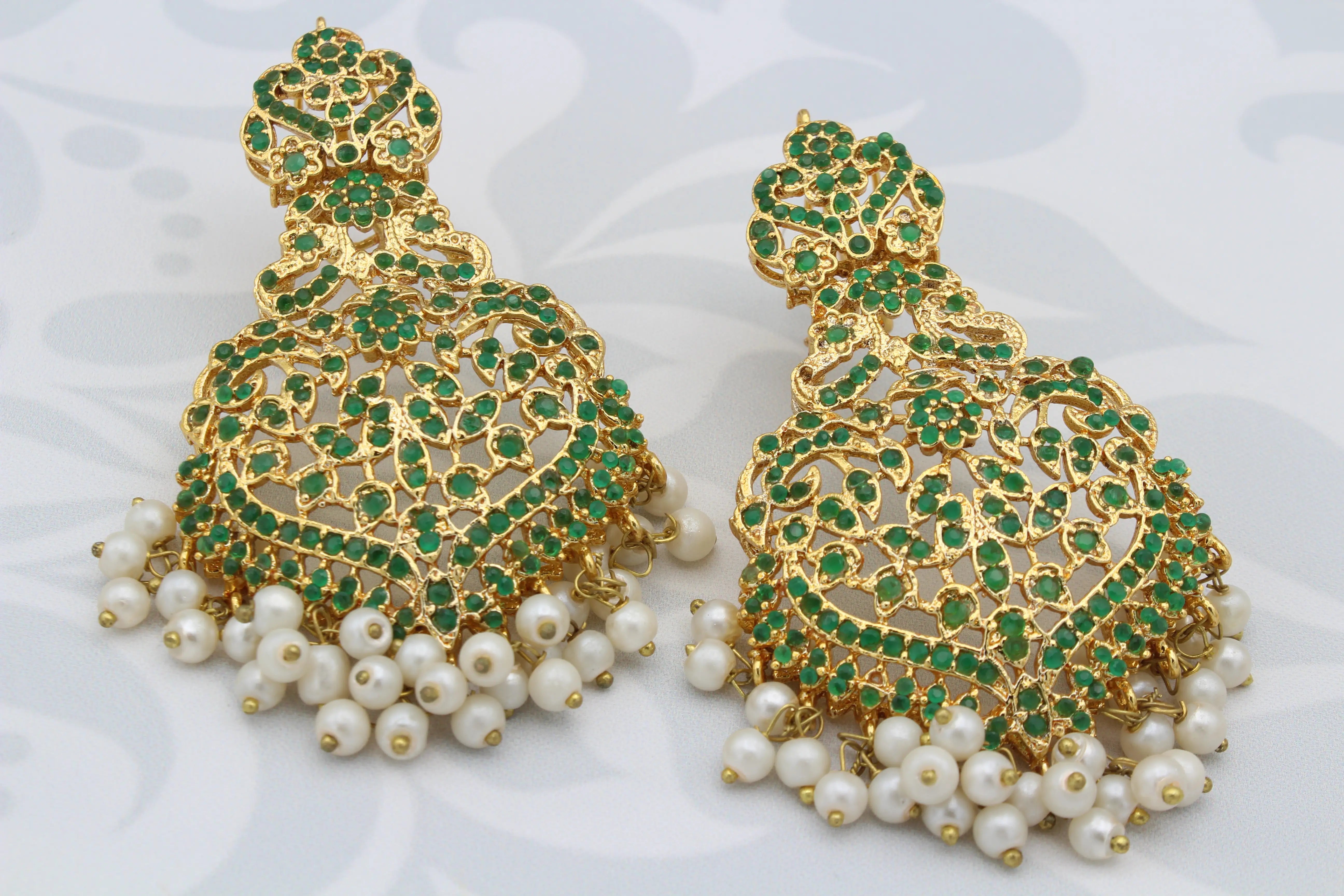 Close-up of Hyderabadi Princess earrings with emerald green stones and pearl fringe