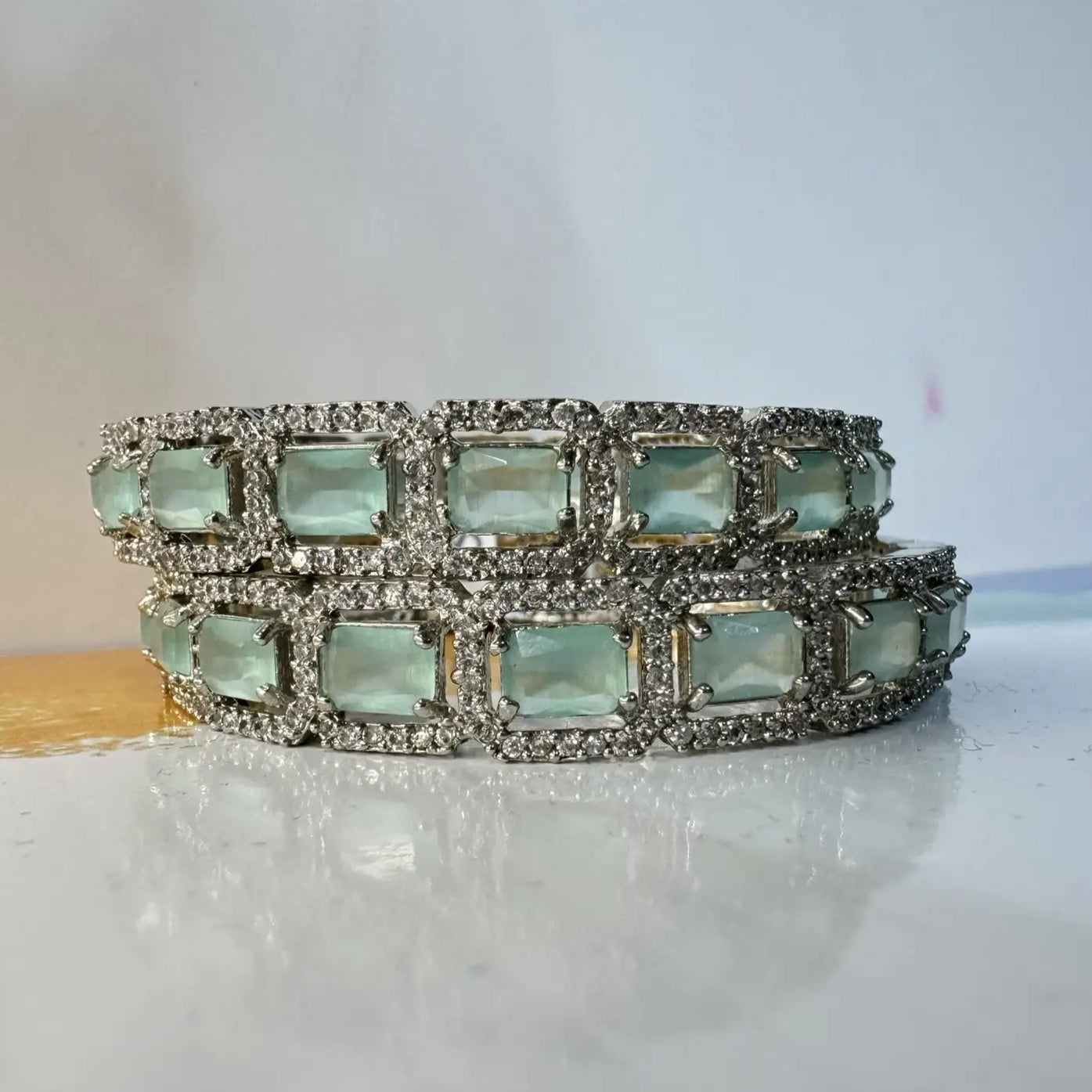 Bangles with teal gemstones and silver accents on a light background