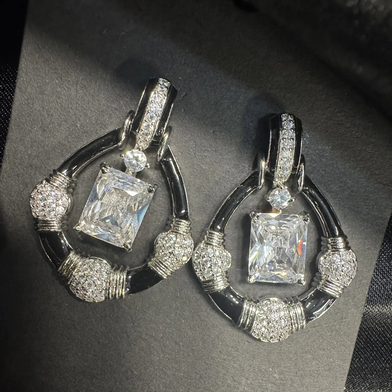 Pair of diamond earrings on a dark background